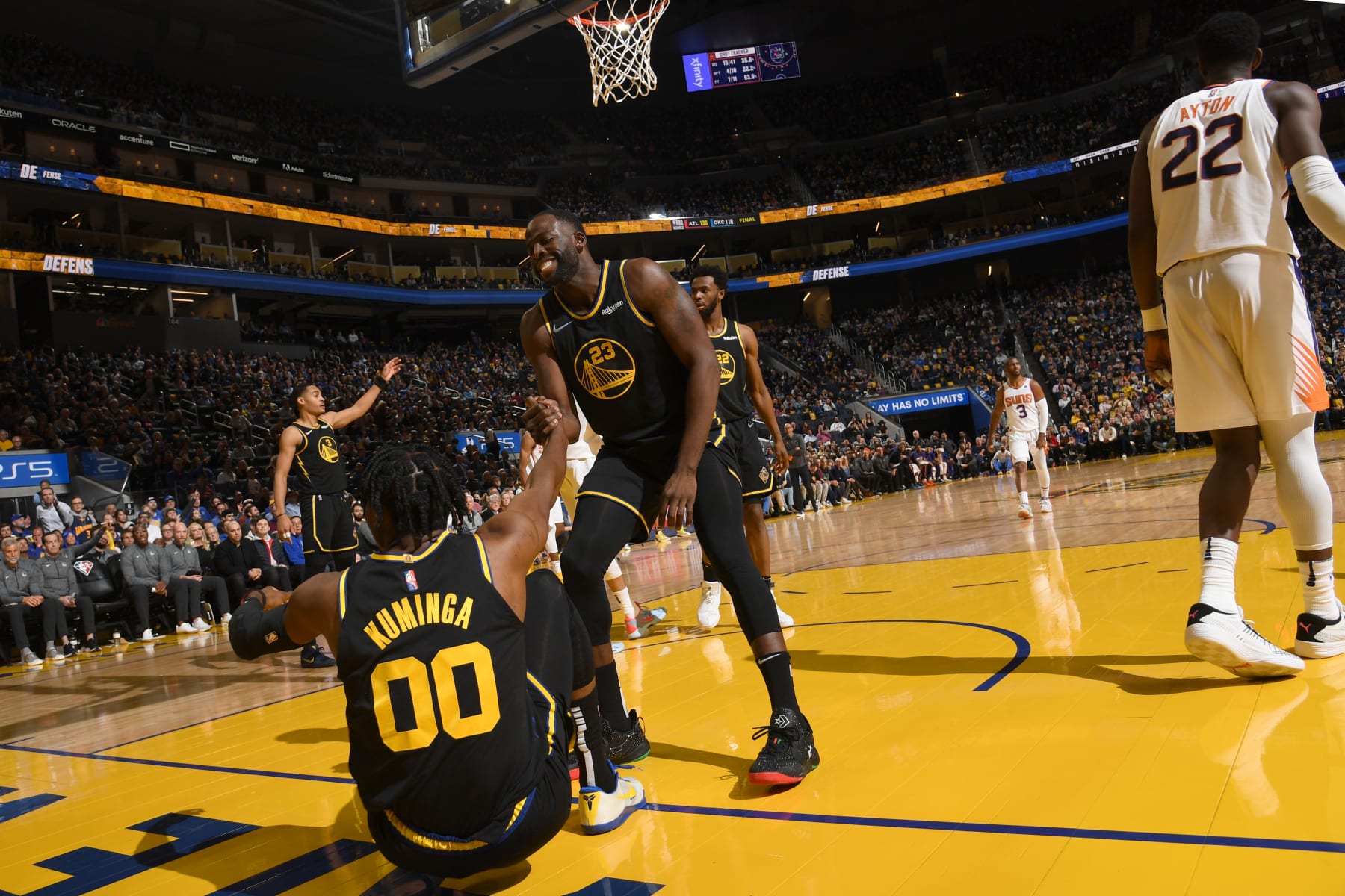 SAN FRANCISCO, CA - MARCH 30: Draymond Green #23 of the Golden State Warriors helps up Jonathan Kuminga #00 during the game against the Phoenix Suns on MARCH 30, 2022 at Chase Center in San Francisco, California. NOTE TO USER: User expressly acknowledges and agrees that, by downloading and or using this photograph, user is consenting to the terms and conditions of Getty Images License Agreement. Mandatory Copyright Notice: Copyright 2022 NBAE (Photo by Noah Graham/NBAE via Getty Images)
