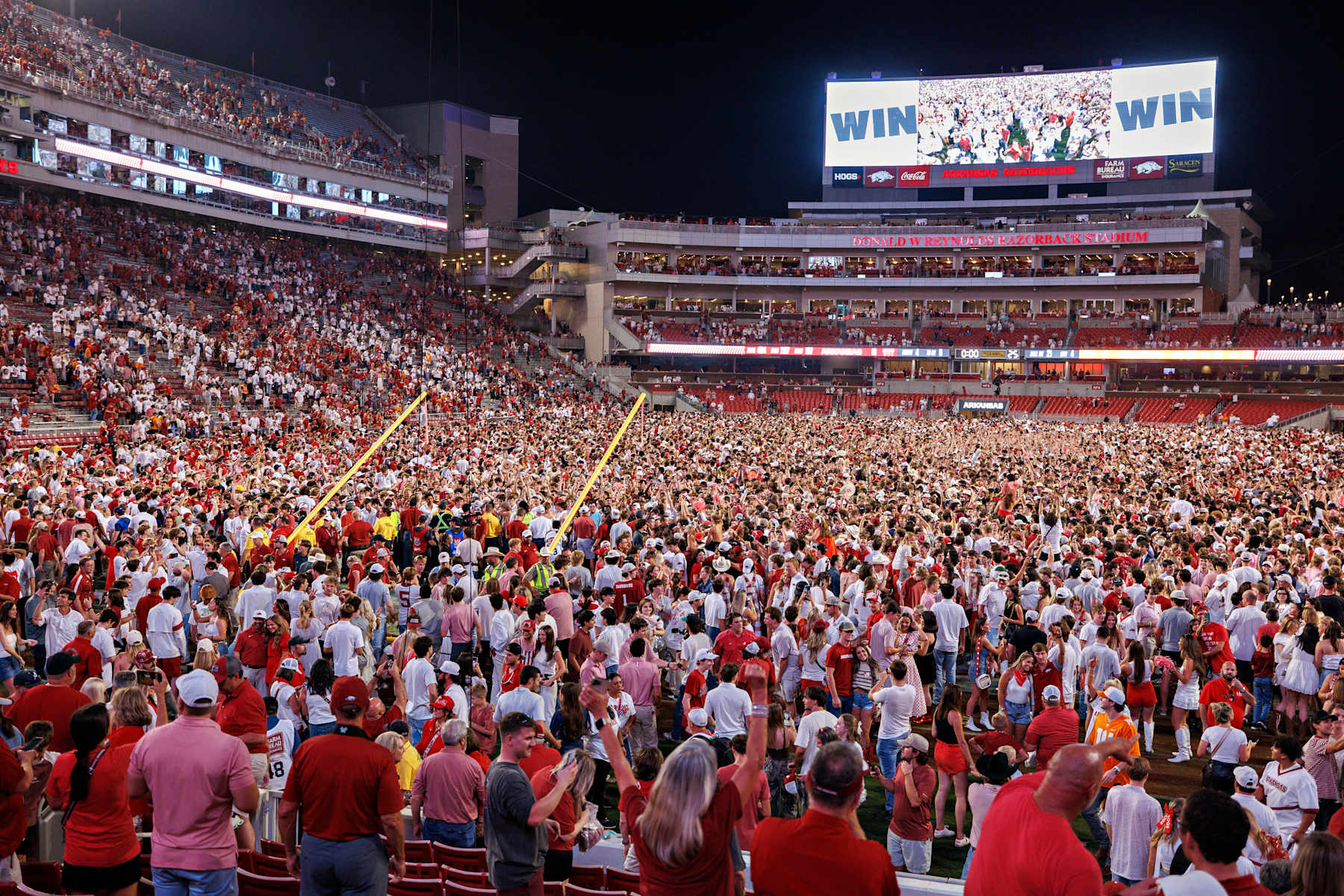 Fans of the Arkansas Razorbacks storm the field after a game against the Tennessee.