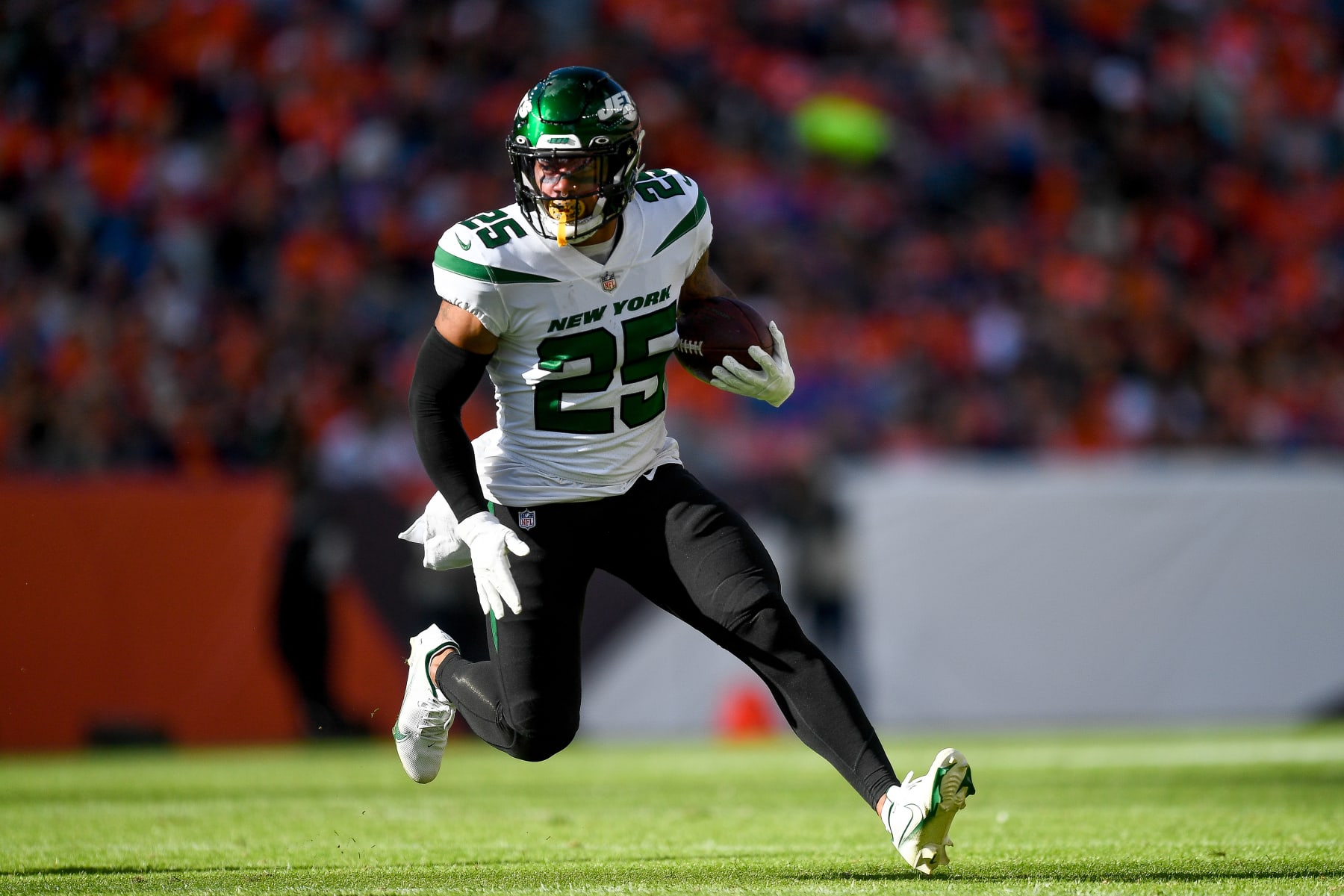 DENVER, COLORADO - OCTOBER 23:  Running back Ty Johnson #25 of the New York Jets rushes against the Denver Broncos in a game at Empower Field at Mile High on October 23, 2022 in Denver, Colorado. (Photo by Dustin Bradford/Getty Images)