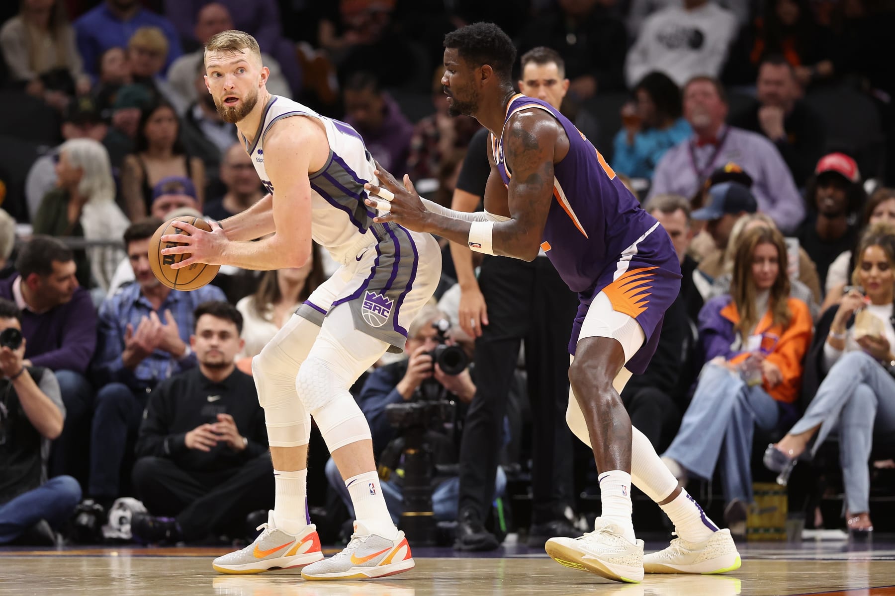 PHOENIX, ARIZONA - FEBRUARY 14: Domantas Sabonis #10 of the Sacramento Kings handles the ball against Deandre Ayton #22 of the Phoenix Suns during the second half of the NBA game at Footprint Center on February 14, 2023 in Phoenix, Arizona. The Suns defeated the Kings 120-109. NOTE TO USER: User expressly acknowledges and agrees that, by downloading and or using this photograph, User is consenting to the terms and conditions of the Getty Images License Agreement. (Photo by Christian Petersen/Getty Images)
