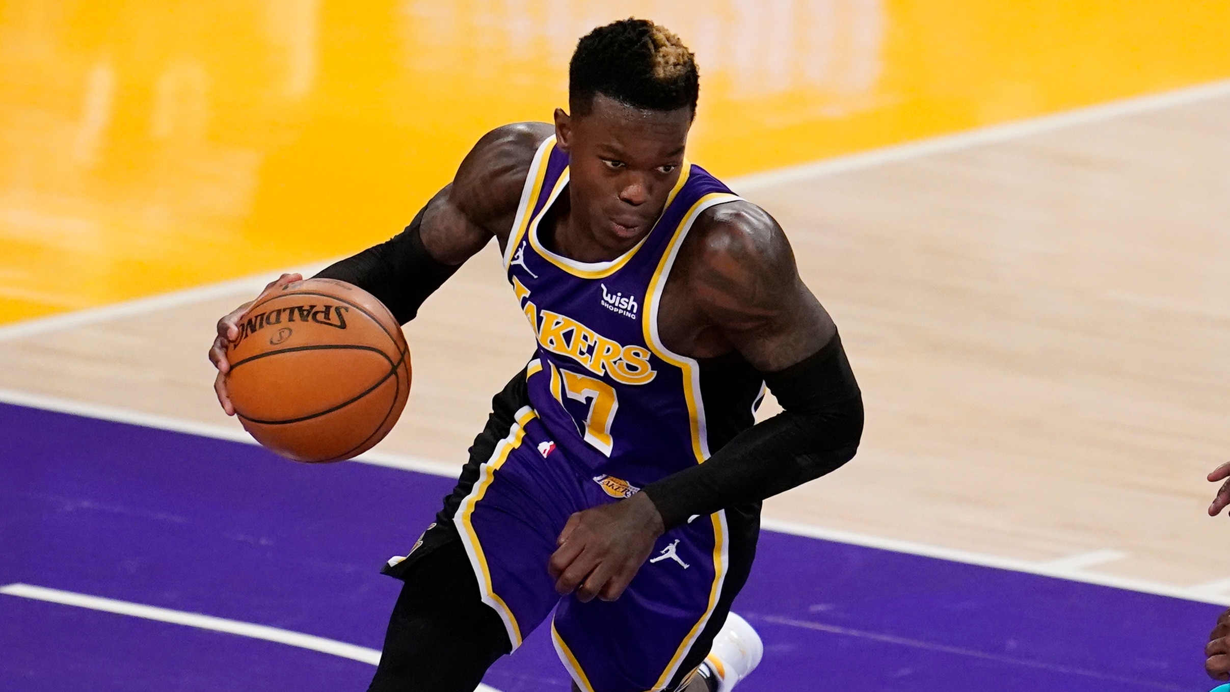 Los Angeles Lakers guard Dennis Schroder dribbles during an NBA basketball game against the Charlotte Hornets Thursday, March 18, 2021, in Los Angeles. (AP Photo/Marcio Jose Sanchez)