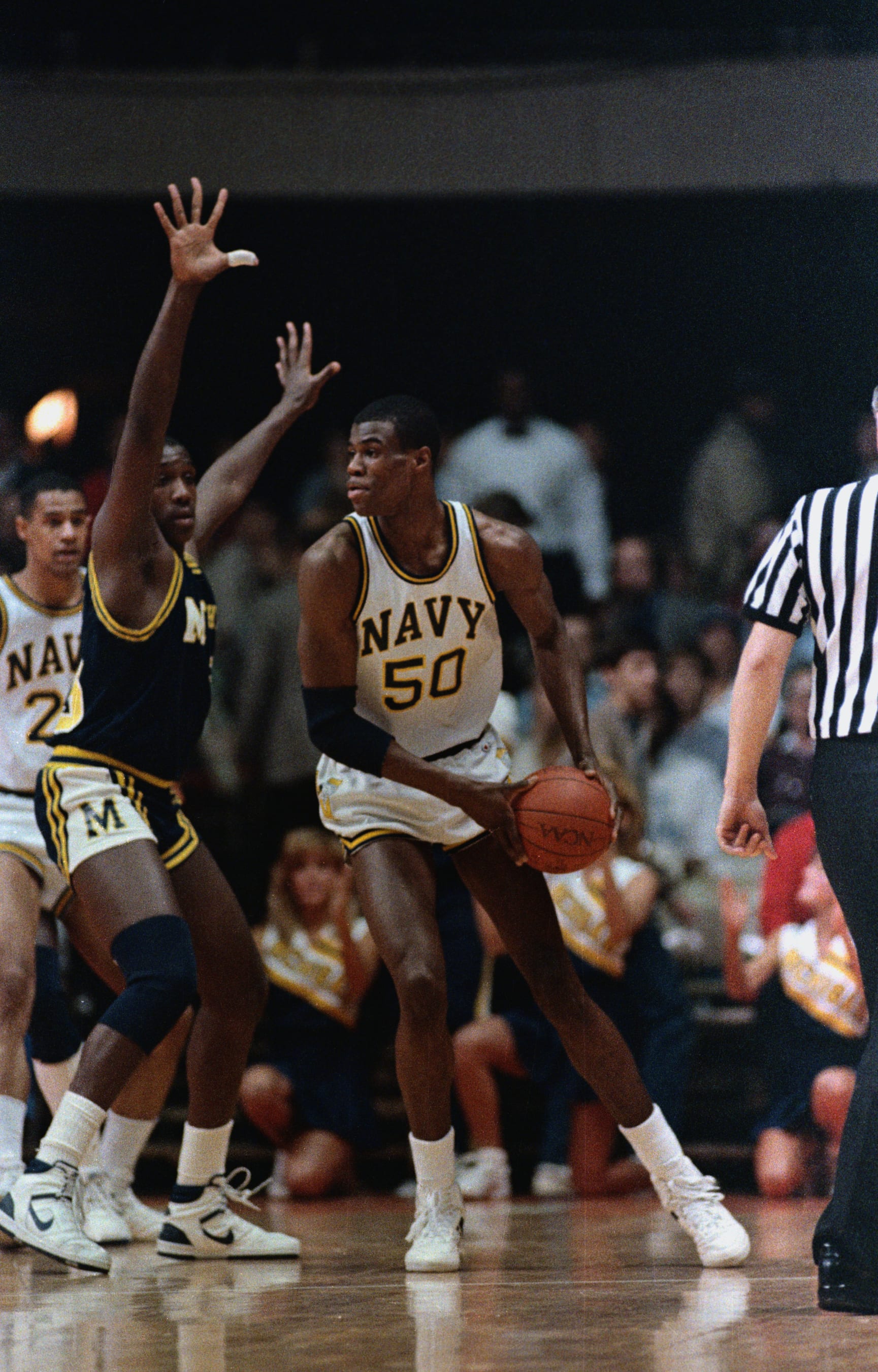 (Original Caption) Annapolis, Maryland: Navy center David Robinson (R), seen in action against Michigan in an NCAA game 3/12, was named 3/25 United Press International's Player of the Year. The 7-foot-1 Middle star, who grew from an unnoticed small forward to the most dominant center in college basketball, capped his career by scoring a school record 50 points in Navy's loss to Michigan.
