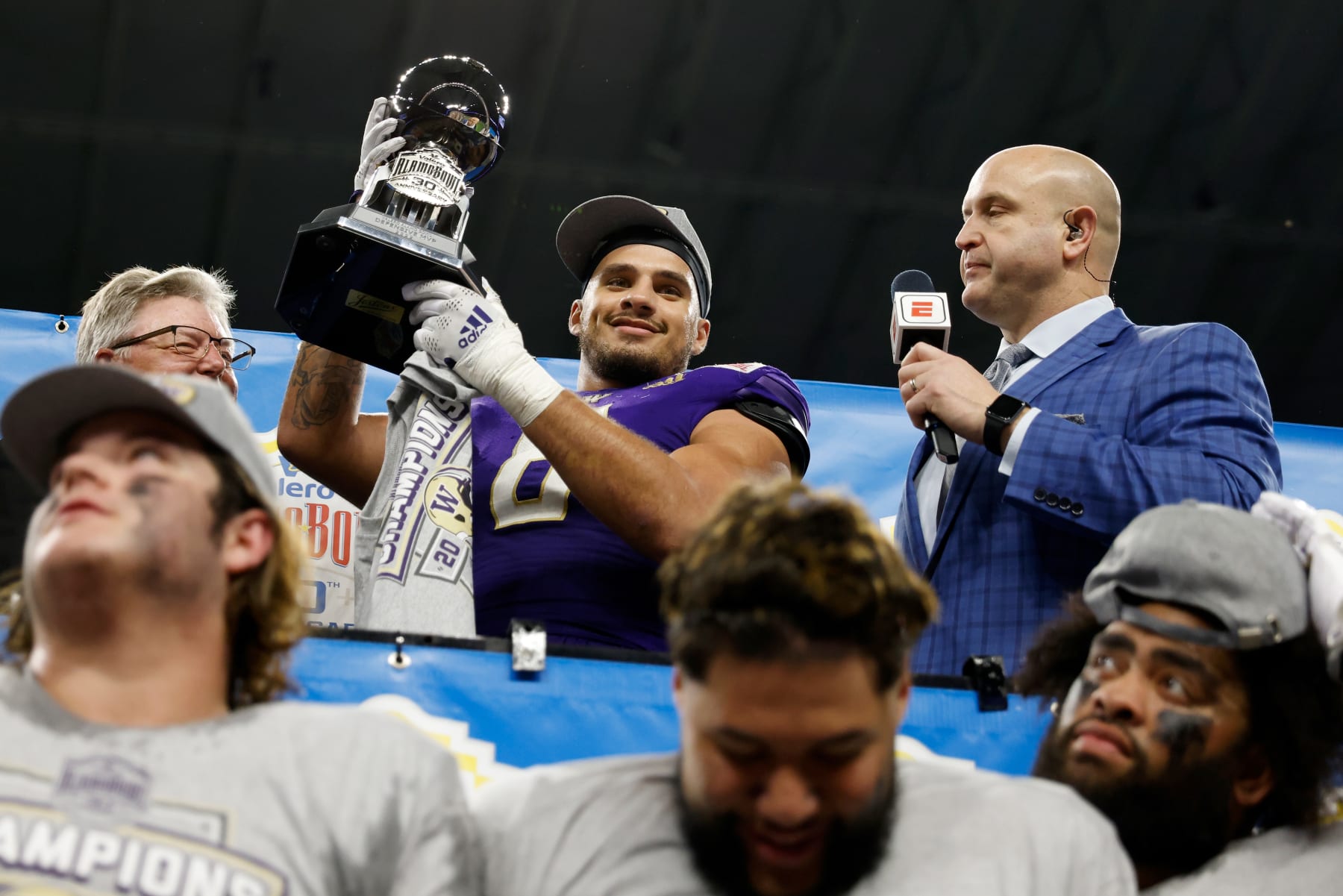 SAN ANTONIO, TEXAS - DECEMBER 29: Bralen Trice #8 of the Washington Huskies receives the defensive player of the game trophy after the Valero Alamo Bowl game against the Texas Longhorns at Alamodome on December 29, 2022 in San Antonio, Texas. (Photo by Tim Warner/Getty Images)