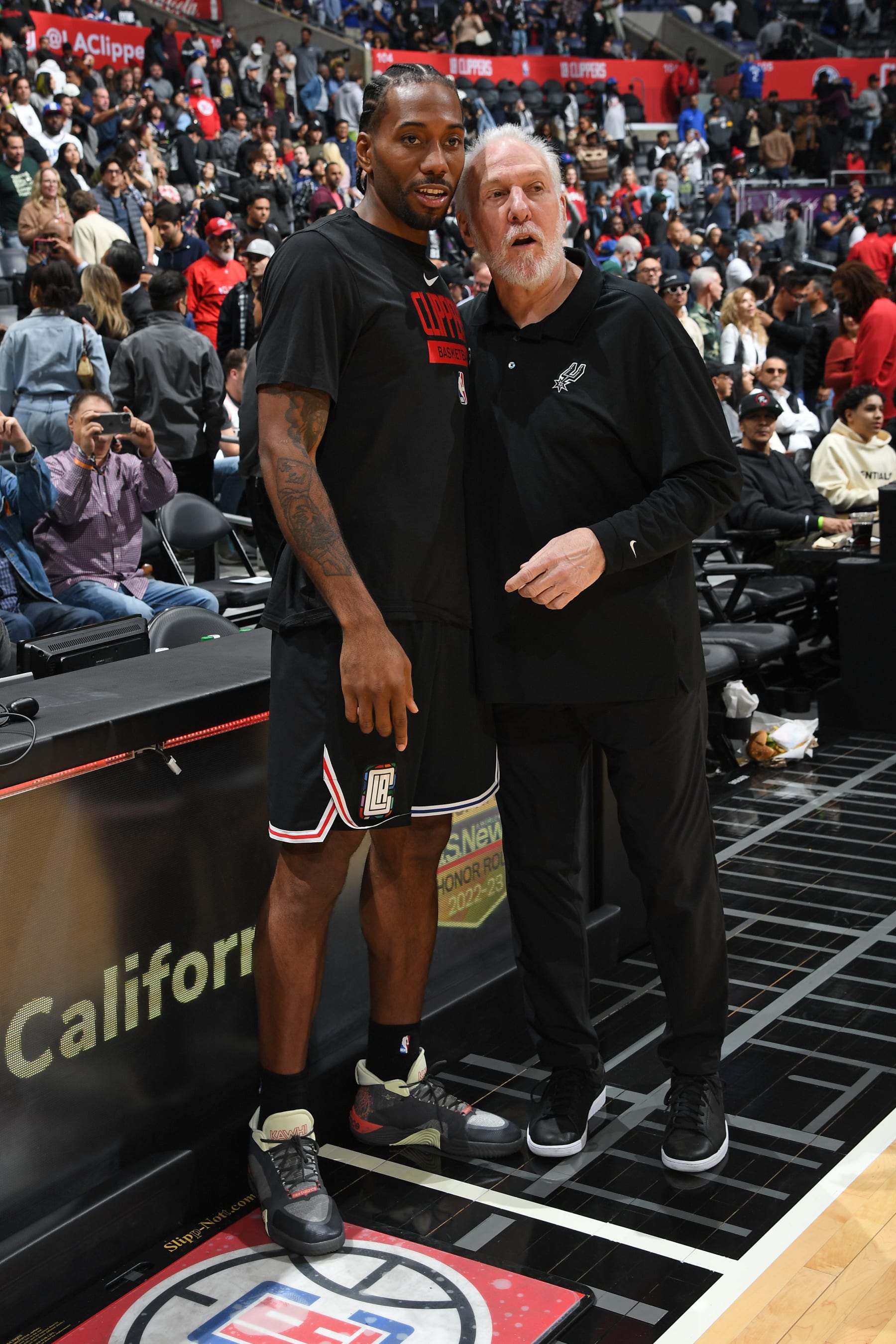 LOS ANGELES, CA - NOVEMBER 19:  Kawhi Leonard #2 of the LA Clippers and Head Coach Gregg Popovich of the San Antonio Spurs talk before the game between the San Antonio Spurs and the LA Clippers on November 19, 2022 at Crypto.Com Arena in Los Angeles, California. NOTE TO USER: User expressly acknowledges and agrees that, by downloading and/or using this Photograph, user is consenting to the terms and conditions of the Getty Images License Agreement. Mandatory Copyright Notice: Copyright 2022 NBAE (Photo by Andrew D. Bernstein/NBAE via Getty Images)