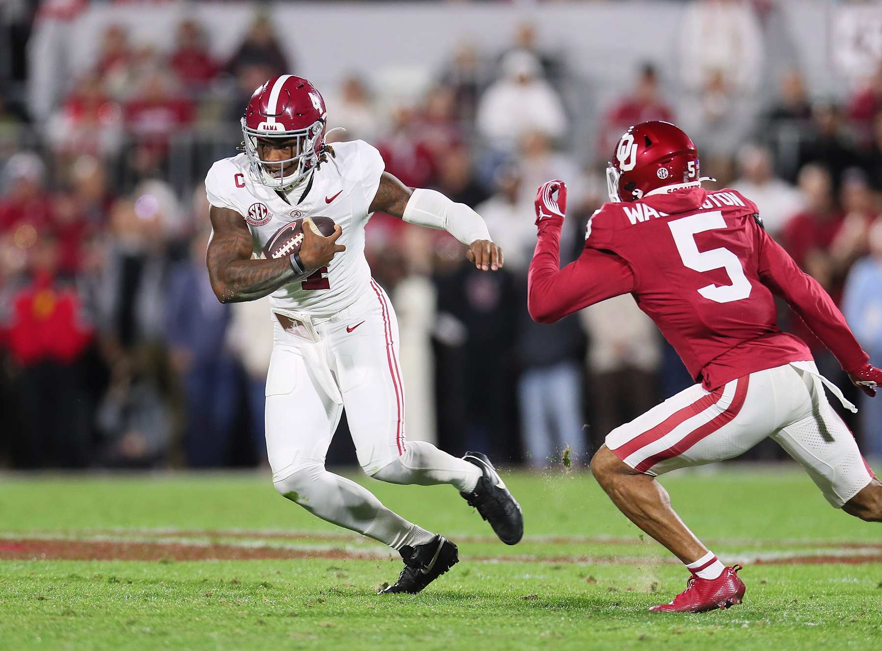 NORMAN, OK - NOVEMBER 23:Alabama Crimson Tide QB Jalen Milroe (04) running away from Oklahoma Sooners DB Woodi Washington (05) during a game between the Oklahoma Sooners and the Alabama Crimson Tide at Gaylord Memorial Stadium in Norman, Oklahoma on November 23, 2024. (Photo by David Stacy/Icon Sportswire via Getty Images)