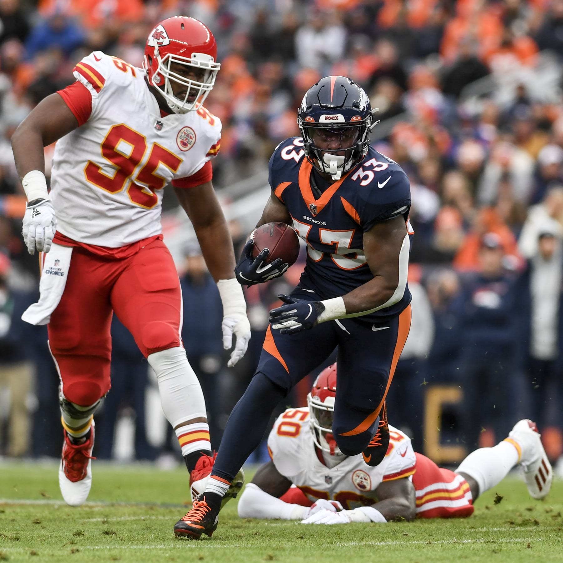 DENVER, CO - JANUARY 8: Javonte Williams (33) of the Denver Broncos runs as Willie Gay Jr. (50) misses a tackle and Chris Jones (95) of the Kansas City Chiefs pursues during the first quarter at Empower Field at Mile High on Saturday, January 8, 2021. (Photo by AAron Ontiveroz/MediaNews Group/The Denver Post via Getty Images)