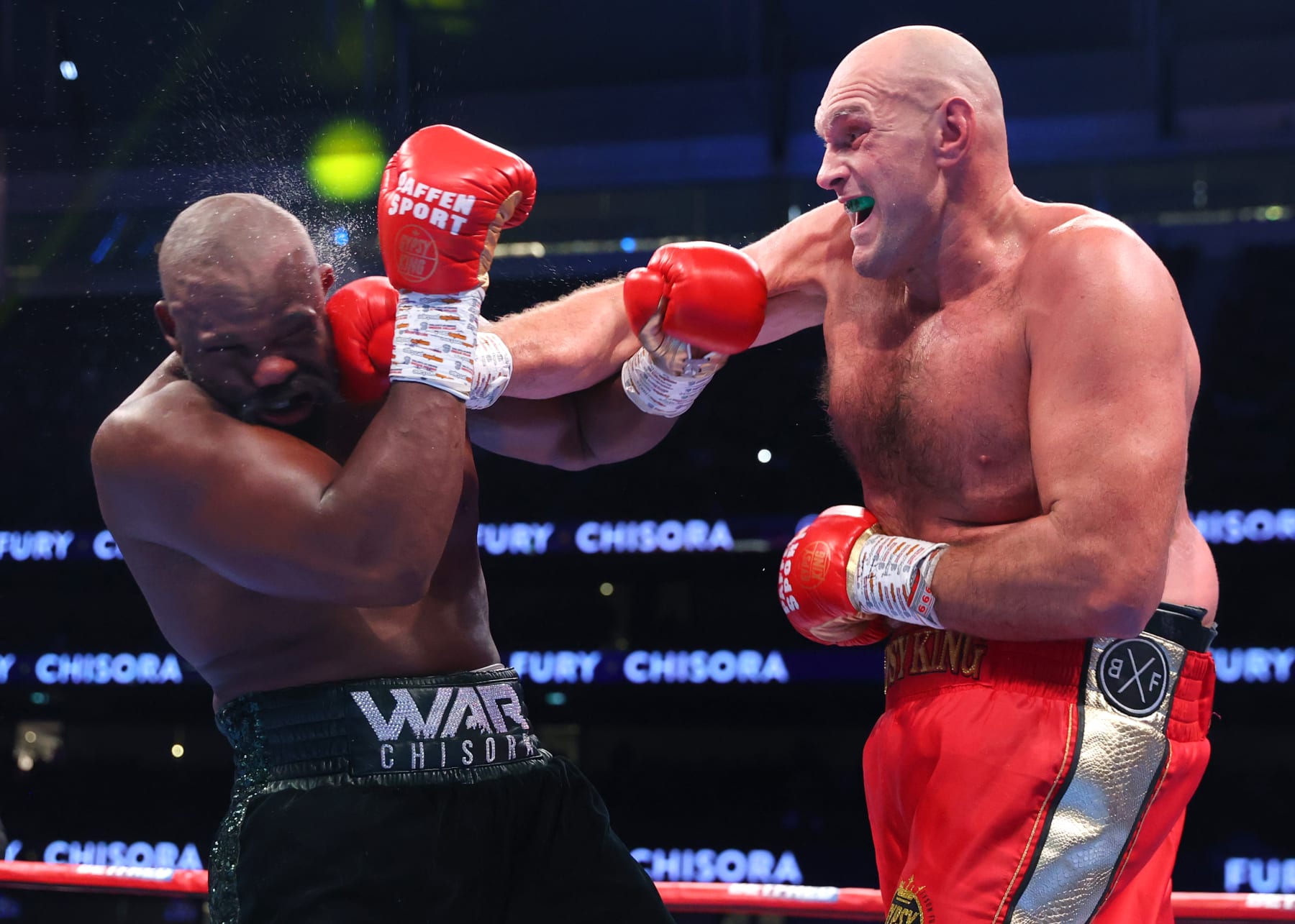 LONDON, ENGLAND - DECEMBER 03: Derek Chisora (L) and Tyson Fury (R) exchange punches during their WBC heavyweight championship fight, at Tottenham Hotspur Stadium on December 03, 2022 in London, England. (Photo by Mikey Williams/Top Rank Inc via Getty Images)