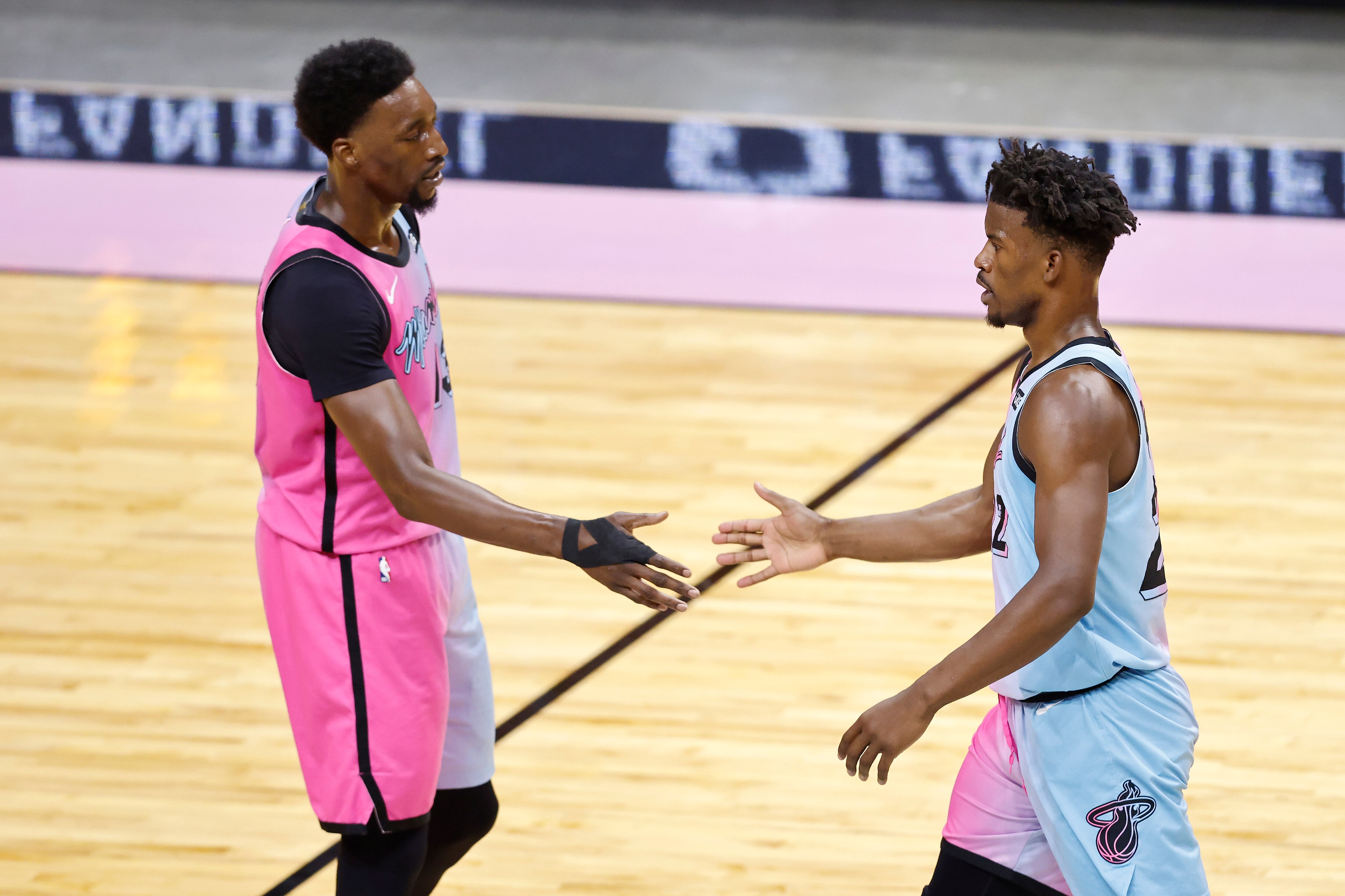 MIAMI, FLORIDA - MAY 13: Jimmy Butler #22 of the Miami Heat high fives Bam Adebayo #13 against the Philadelphia 76ers during the first quarter at American Airlines Arena on May 13, 2021 in Miami, Florida. NOTE TO USER: User expressly acknowledges and agrees that, by downloading and or using this photograph, User is consenting to the terms and conditions of the Getty Images License Agreement. (Photo by Michael Reaves/Getty Images)