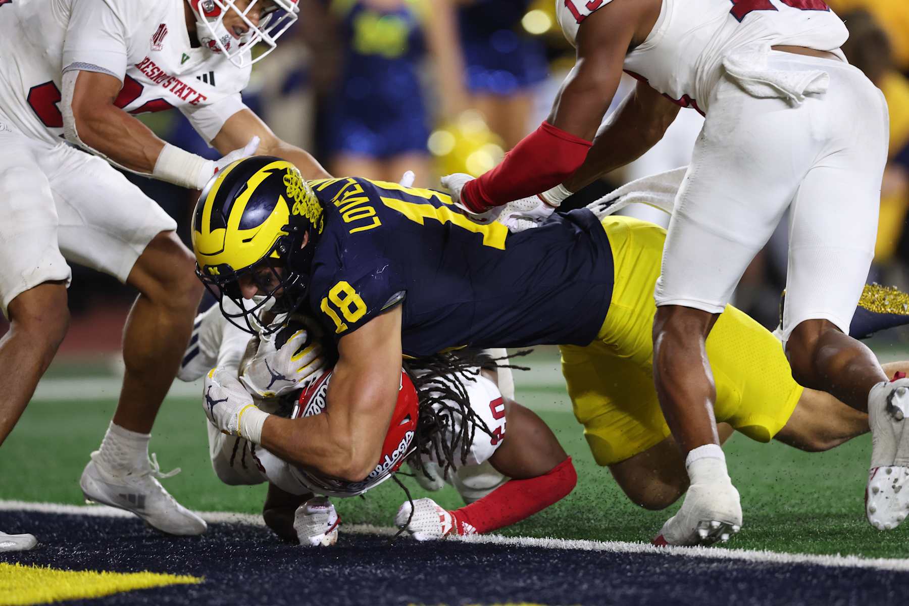 ANN ARBOR, MICHIGAN - AUGUST 31: Colston Loveland #18 of the Michigan Wolverines scores a second half touchdown over RJ Regan #20 of the Fresno State Bulldogs at Michigan Stadium on August 31, 2024 in Ann Arbor, Michigan.  (Photo by Gregory Shamus/Getty Images)