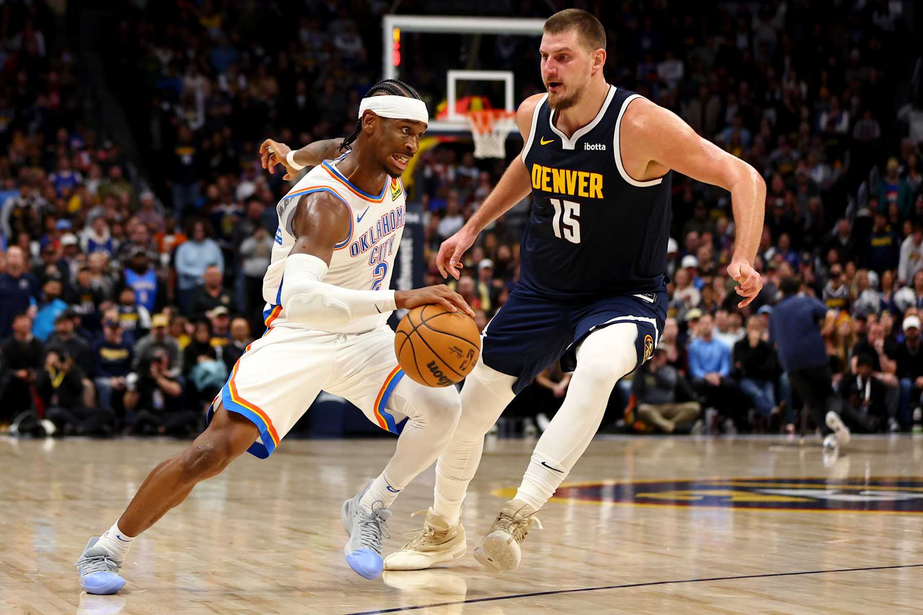 DENVER, COLORADO - NOVEMBER 6: Shai Gilgeous-Alexander #2 of the Oklahoma City Thunder drives against Nikola Jokic #15 of the Denver Nuggets at Ball Arena on November 6, 2024 in Denver, Colorado. NOTE TO USER: User expressly acknowledges and agrees that, by downloading and/or using this Photograph, user is consenting to the terms and conditions of the Getty Images License Agreement. (Photo by Jamie Schwaberow/Getty Images)