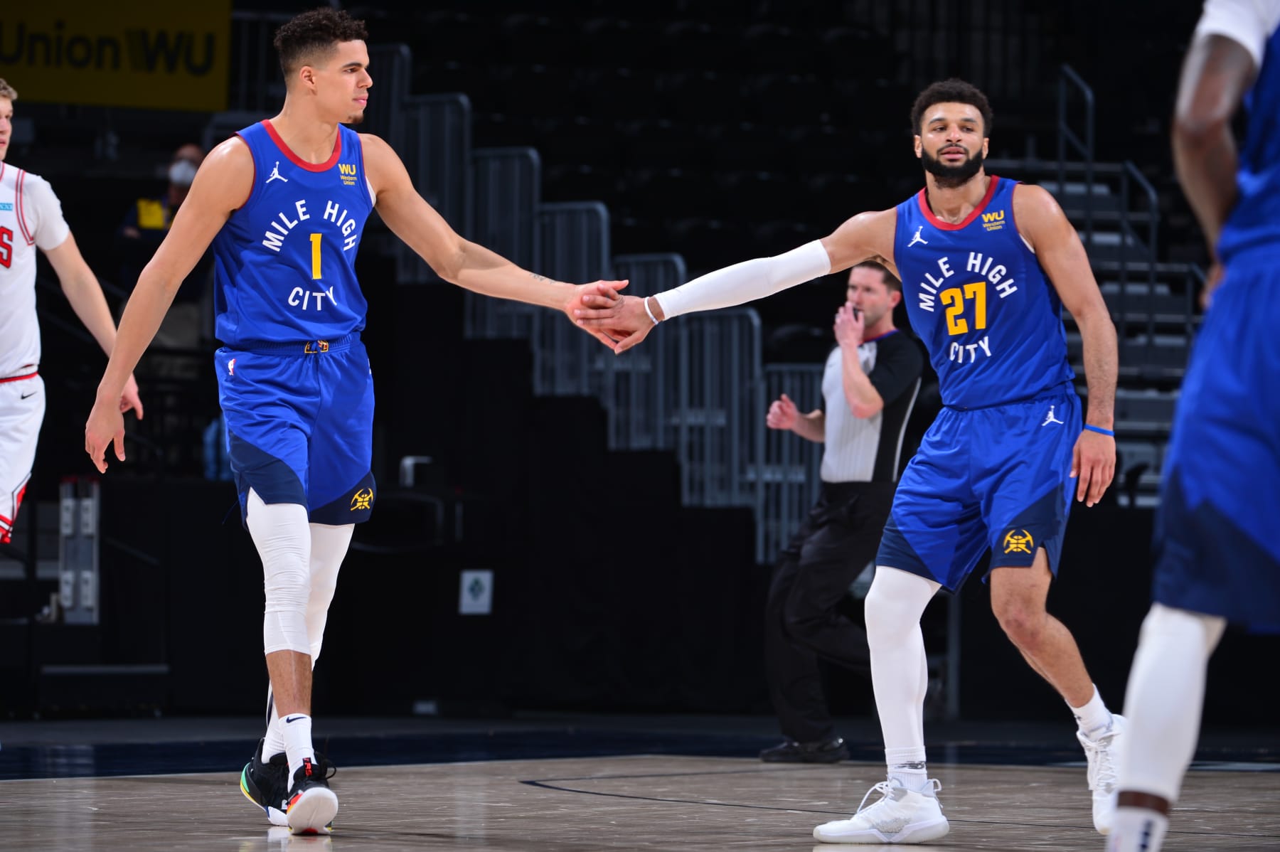 DENVER, CO - MARCH 19: Michael Porter Jr. #1 of the Denver Nuggets high-fives teammate Jamal Murray #27 during the game against the Chicago Bulls on March 19, 2021 at the Ball Arena in Denver, Colorado. NOTE TO USER: User expressly acknowledges and agrees that, by downloading and/or using this Photograph, user is consenting to the terms and conditions of the Getty Images License Agreement. Mandatory Copyright Notice: Copyright 2021 NBAE (Photo by Bart Young/NBAE via Getty Images)