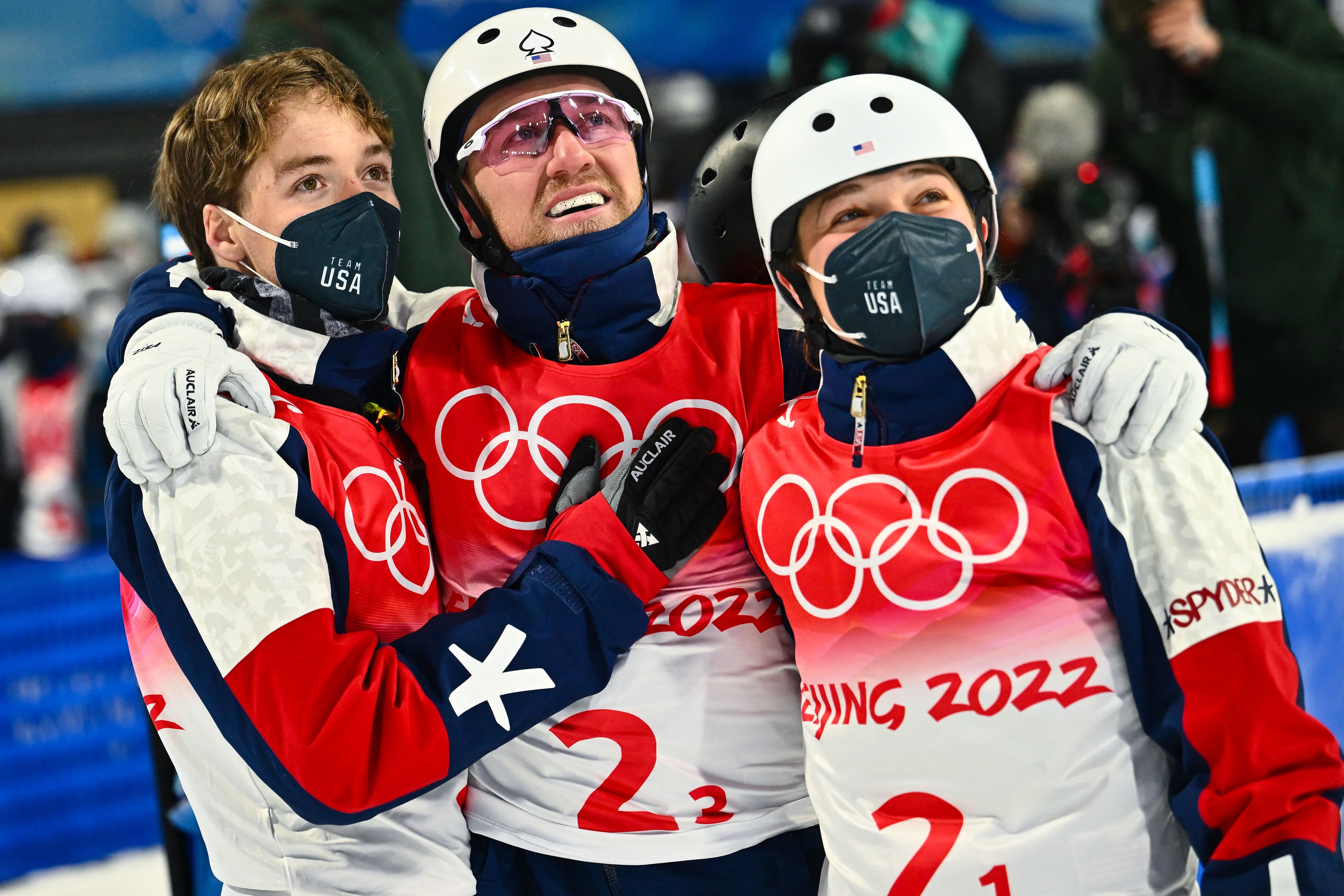 USA's Justin Schoenefeld (C), USA's Ashley Caldwell (R) and USA's Christopher Lillis wait for their score in the freestyle skiing mixed team aerials final during the Beijing 2022 Winter Olympic Games at the Genting Snow Park A & M Stadium in Zhangjiakou on February 10, 2022. (Photo by Marco BERTORELLO / AFP) (Photo by MARCO BERTORELLO/AFP via Getty Images)