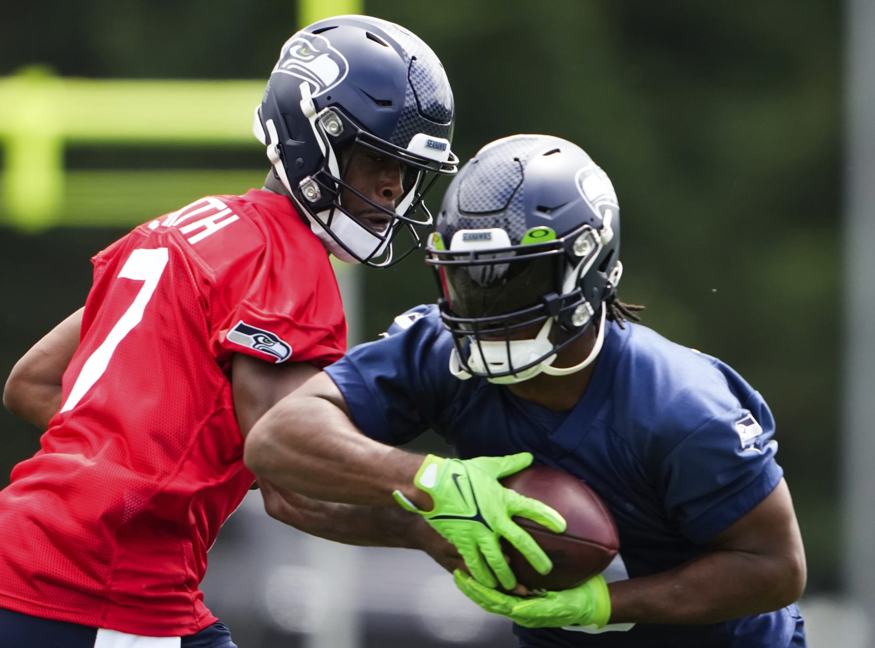 Seattle Seahawks running back Kenneth Walker III takes a handoff from quarterback Geno Smith.