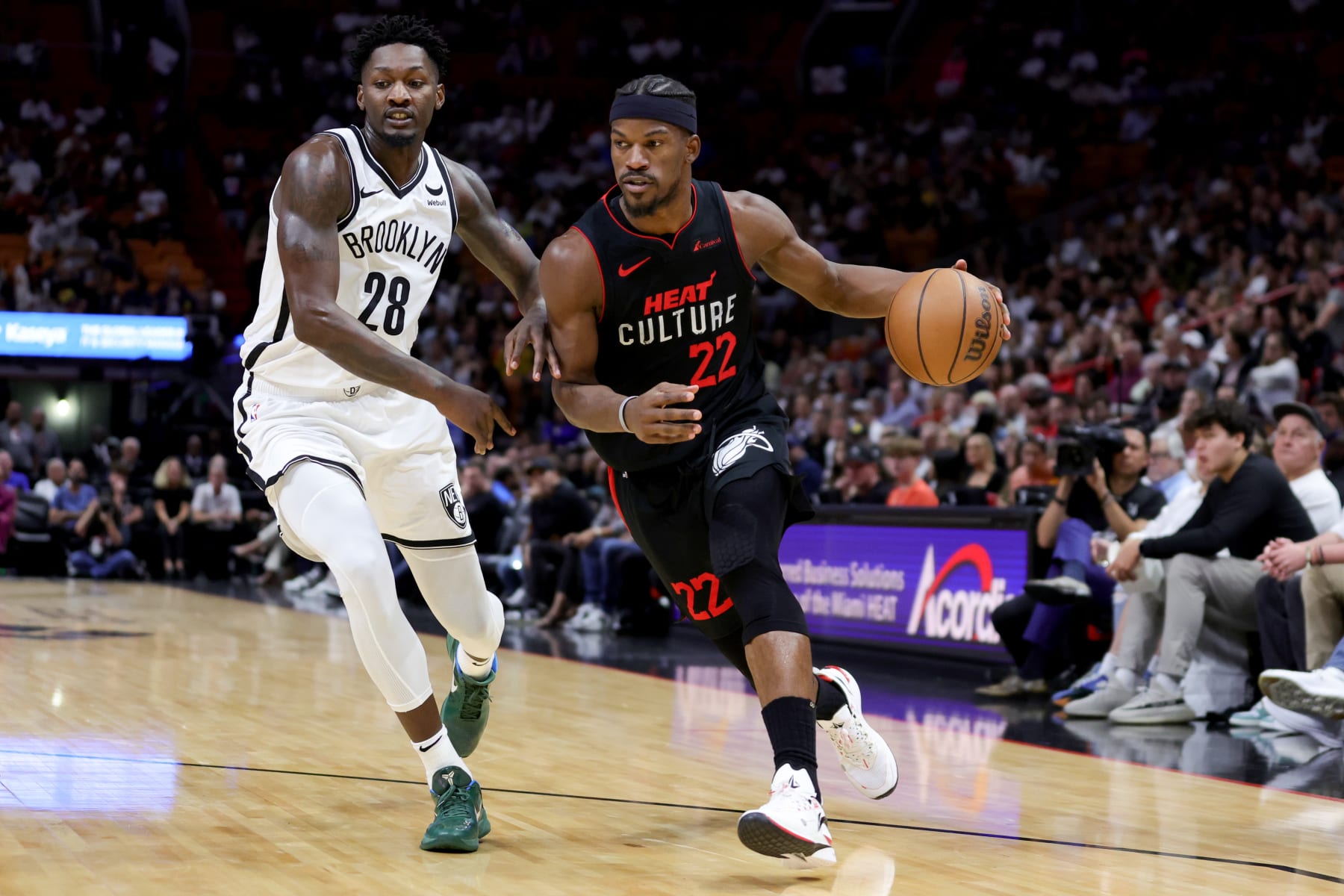 MIAMI, FLORIDA - NOVEMBER 16: Jimmy Butler #22 of the Miami Heat drives against Dorian Finney-Smith #28 of the Brooklyn Nets during the first quarter of the game at Kaseya Center on November 16, 2023 in Miami, Florida. NOTE TO USER: User expressly acknowledges and agrees that, by downloading and or using this photograph, User is consenting to the terms and conditions of the Getty Images License Agreement. (Photo by Megan Briggs/Getty Images)
