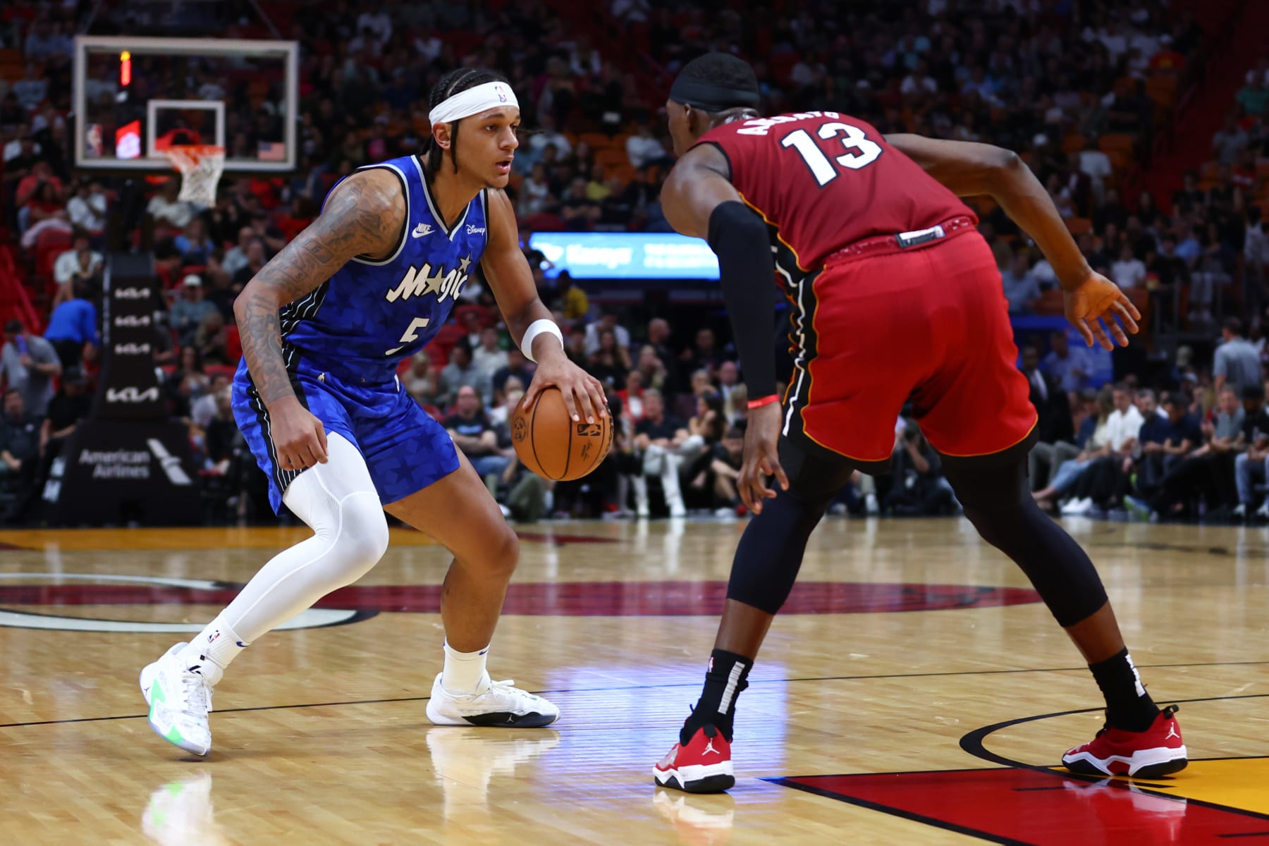 MIAMI, FLORIDA - JANUARY 12: Paolo Banchero #5 of the Orlando Magic dribbles the ball against Bam Adebayo #13 of the Miami Heat during the first quarter of the game at Kaseya Center on January 12, 2024 in Miami, Florida. NOTE TO USER: User expressly acknowledges and agrees that, by downloading and or using this photograph, User is consenting to the terms and conditions of the Getty Images License Agreement. (Photo by Megan Briggs/Getty Images)