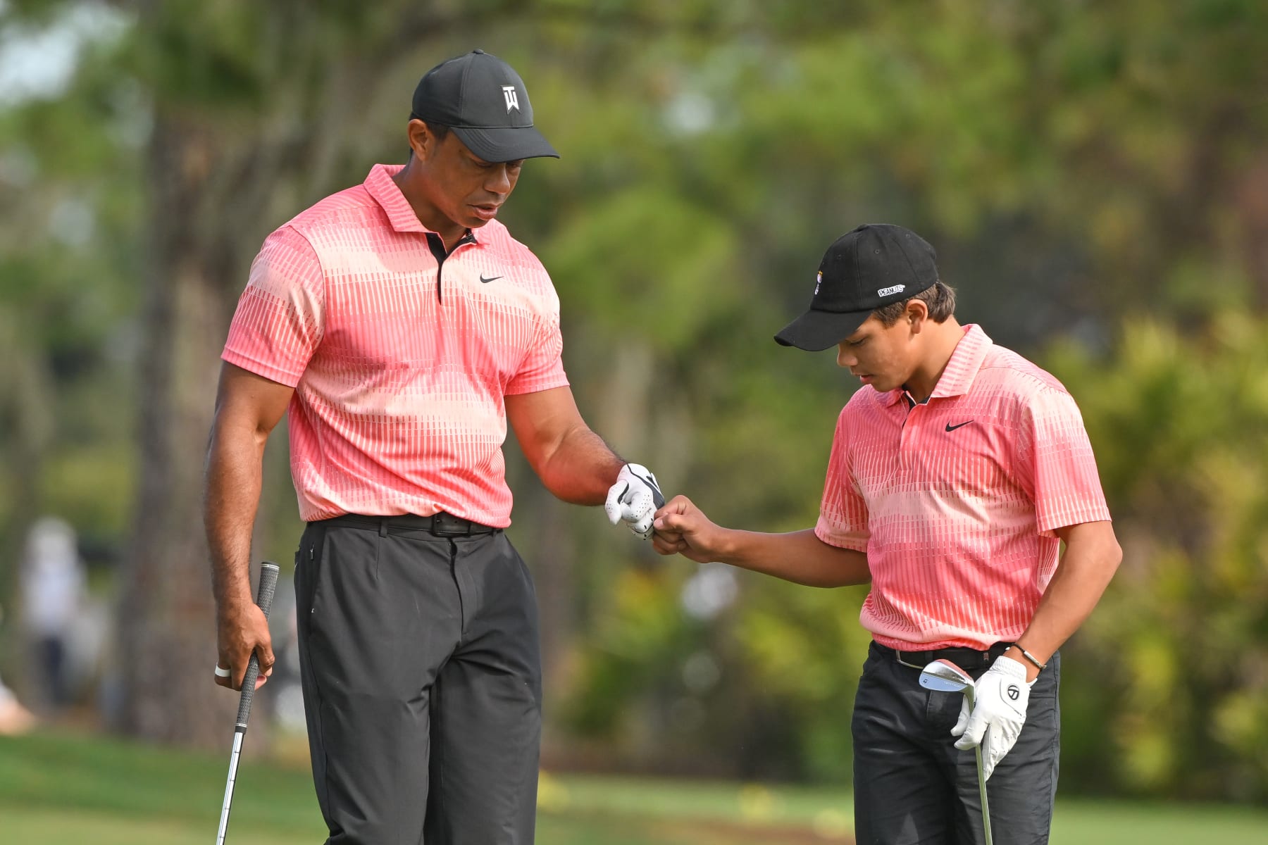 ORLANDO, FLORIDA - DECEMBER 17: Tiger Woods and his son, Charlie Woods, first bump on the second hole during the first round of the PGA TOUR Champions PNC Championship at The Ritz-Carlton Golf Club on December 17, 2022 in Orlando, Florida. (Photo by Ben Jared/PGA TOUR via Getty Images)
