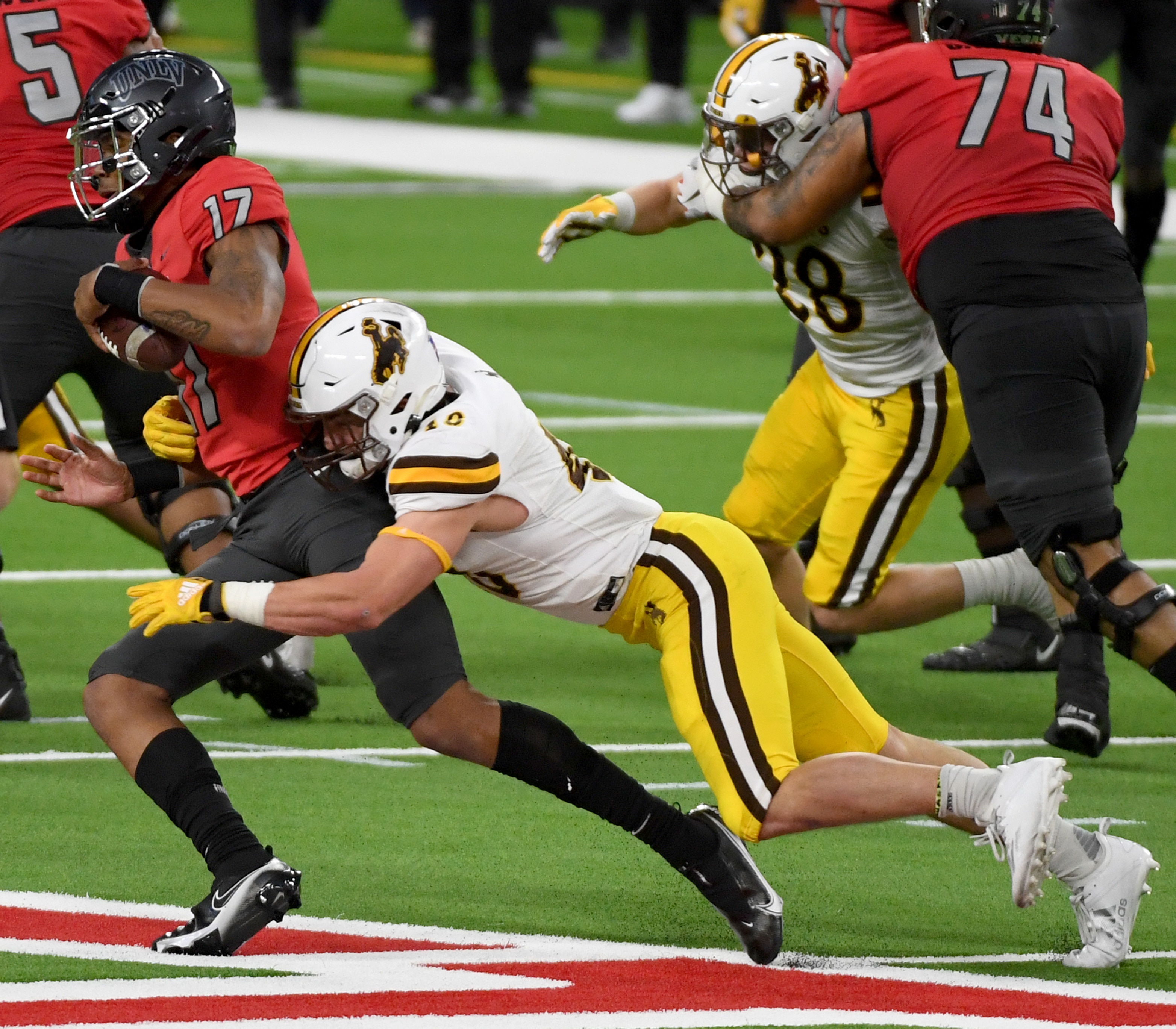 LAS VEGAS, NEVADA - NOVEMBER 27:  Quarterback Doug Brumfield #17 of the UNLV Rebels is sacked by linebacker Chad Muma #48 of the Wyoming Cowboys in the second half of their game at Allegiant Stadium on November 27, 2020 in Las Vegas, Nevada. The Cowboys defeated the Rebels 45-14.  (Photo by Ethan Miller/Getty Images)