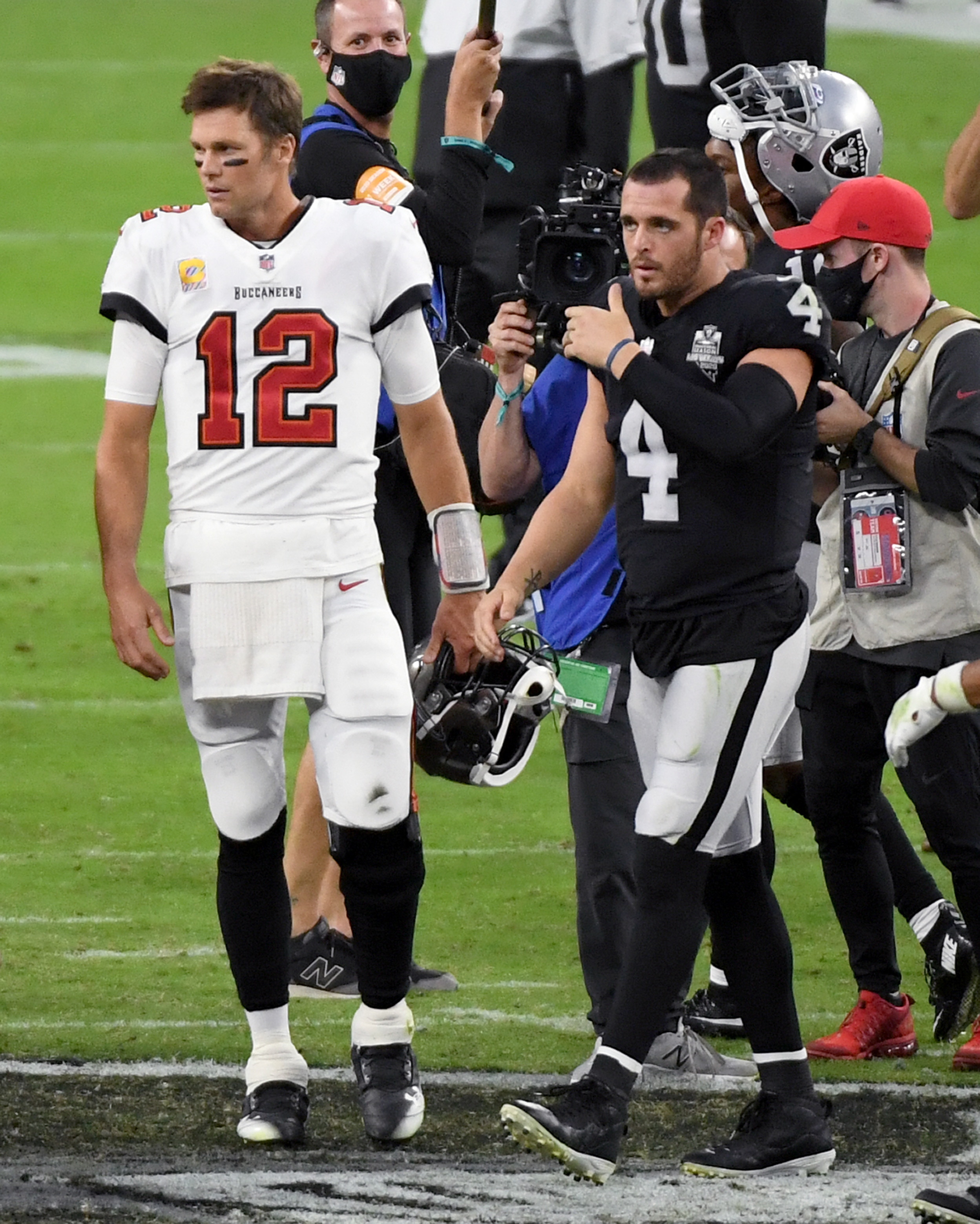 LAS VEGAS, NEVADA - OCTOBER 25:  Quarterback Tom Brady #12 of the Tampa Bay Buccaneers and quarterback Derek Carr #4 of the Las Vegas Raiders walk off the field after their game at Allegiant Stadium on October 25, 2020 in Las Vegas, Nevada. The Buccaneers defeated the Raiders 45-20.  (Photo by Ethan Miller/Getty Images)