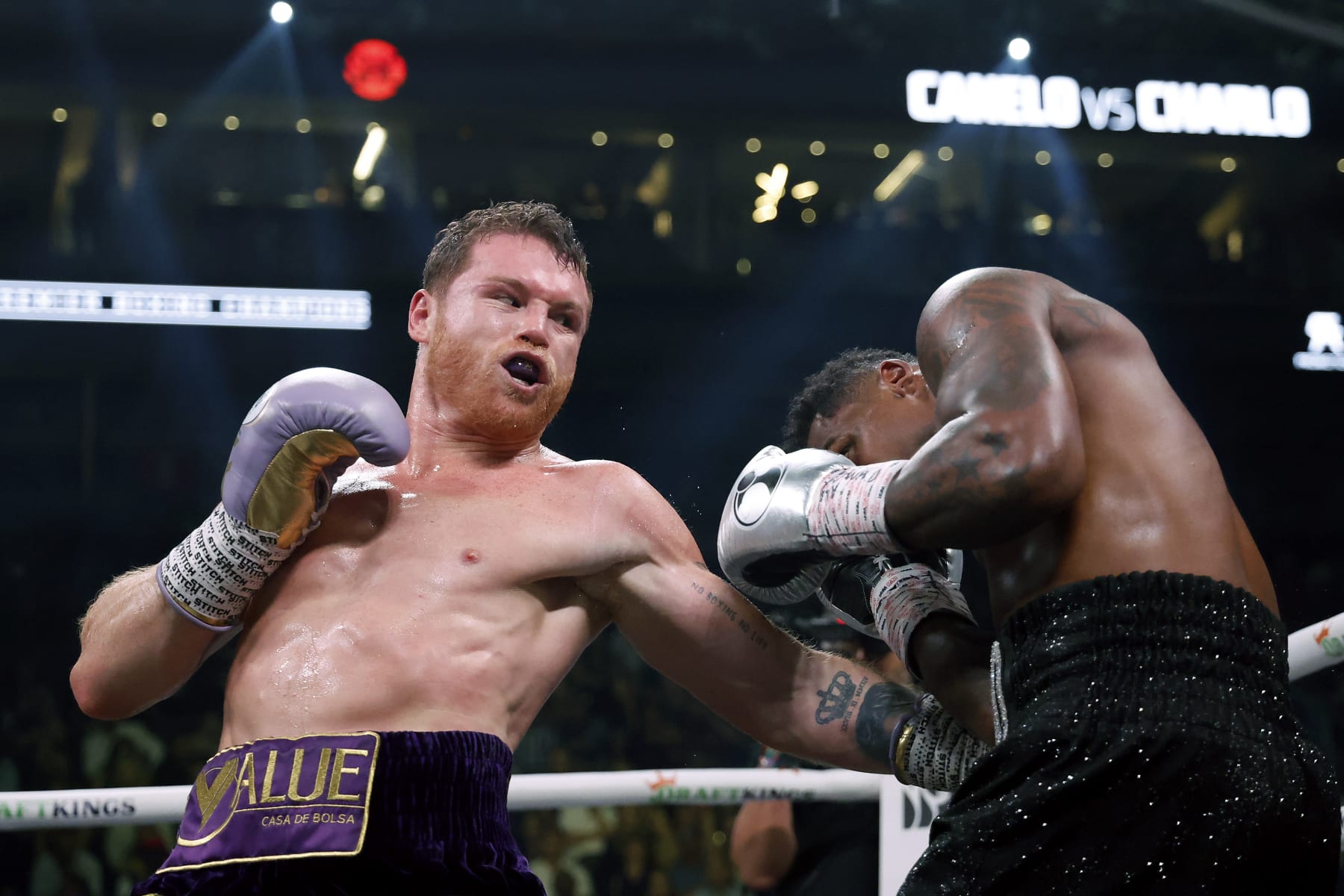LAS VEGAS, NEVADA - SEPTEMBER 30:   Saul "Canelo" Alvarez of Mexico (purple/gold trunks) trades punches with Jermell Charlo (black trunks) during their super middleweight title fight at T-Mobile Arena on September 30, 2023 in Las Vegas, Nevada.  (Photo by Sarah Stier/Getty Images)