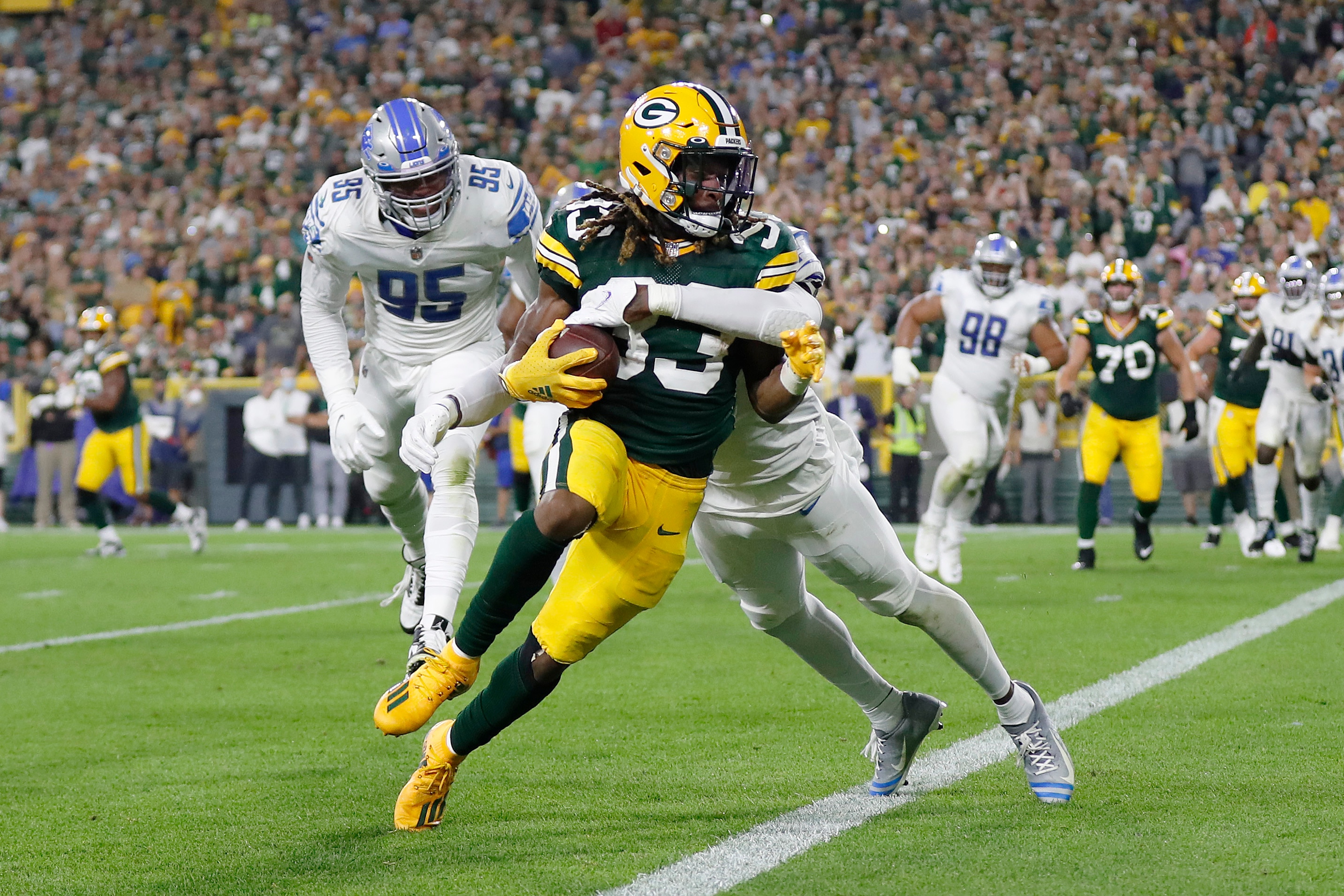 GREEN BAY, WISCONSIN - SEPTEMBER 20: Aaron Jones #33 of the Green Bay Packers runs for a touchdown against Tracy Walker III #21 of the Detroit Lions during the first half at Lambeau Field on September 20, 2021 in Green Bay, Wisconsin. (Photo by Wesley Hitt/Getty Images)