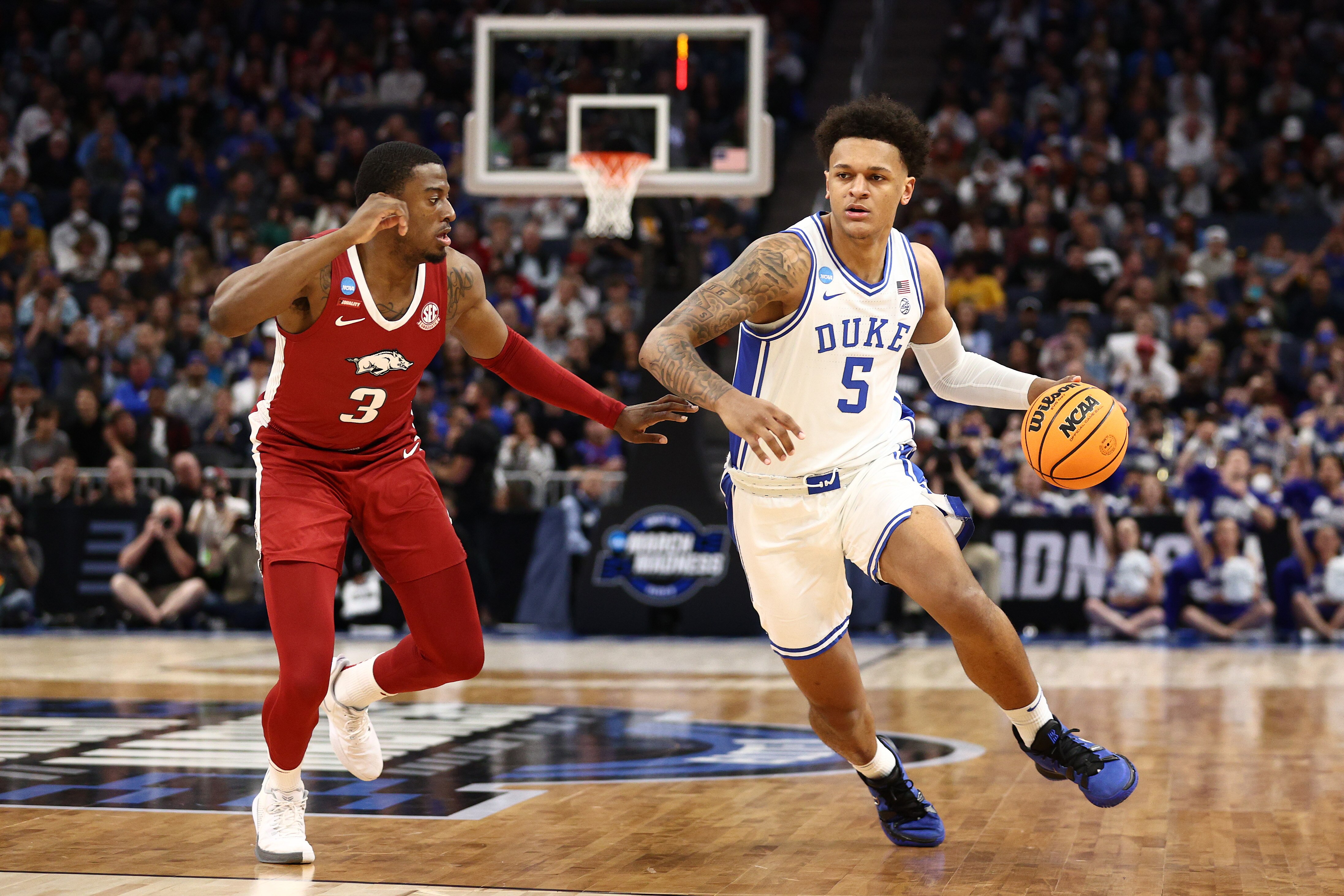 SAN FRANCISCO, CALIFORNIA - MARCH 26: Paolo Banchero #5 of the Duke Blue Devils dribbles the ball in front of Trey Wade #3 of the Arkansas Razorbacks during the first half in the NCAA Men's Basketball Tournament Elite 8 Round at Chase Center on March 26, 2022 in San Francisco, California. (Photo by Ezra Shaw/Getty Images)