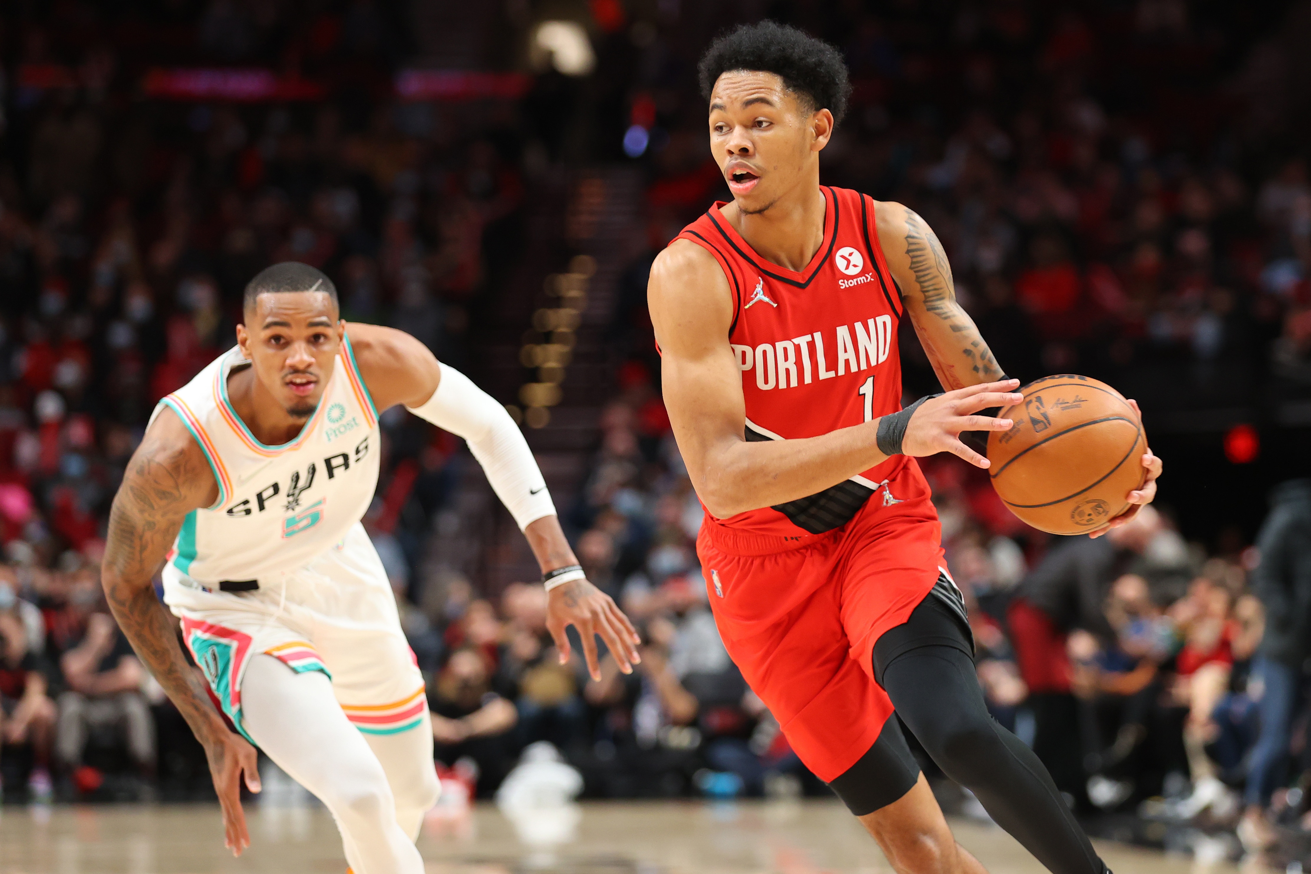 PORTLAND, OREGON - DECEMBER 02: Anfernee Simons #1 of the Portland Trail Blazers handles the ball against Dejounte Murray #5 of the San Antonio Spurs during the first quarter at Moda Center on December 02, 2021 in Portland, Oregon. NOTE TO USER: User expressly acknowledges and agrees that, by downloading and or using this photograph, User is consenting to the terms and conditions of the Getty Images License Agreement.  (Photo by Abbie Parr/Getty Images)