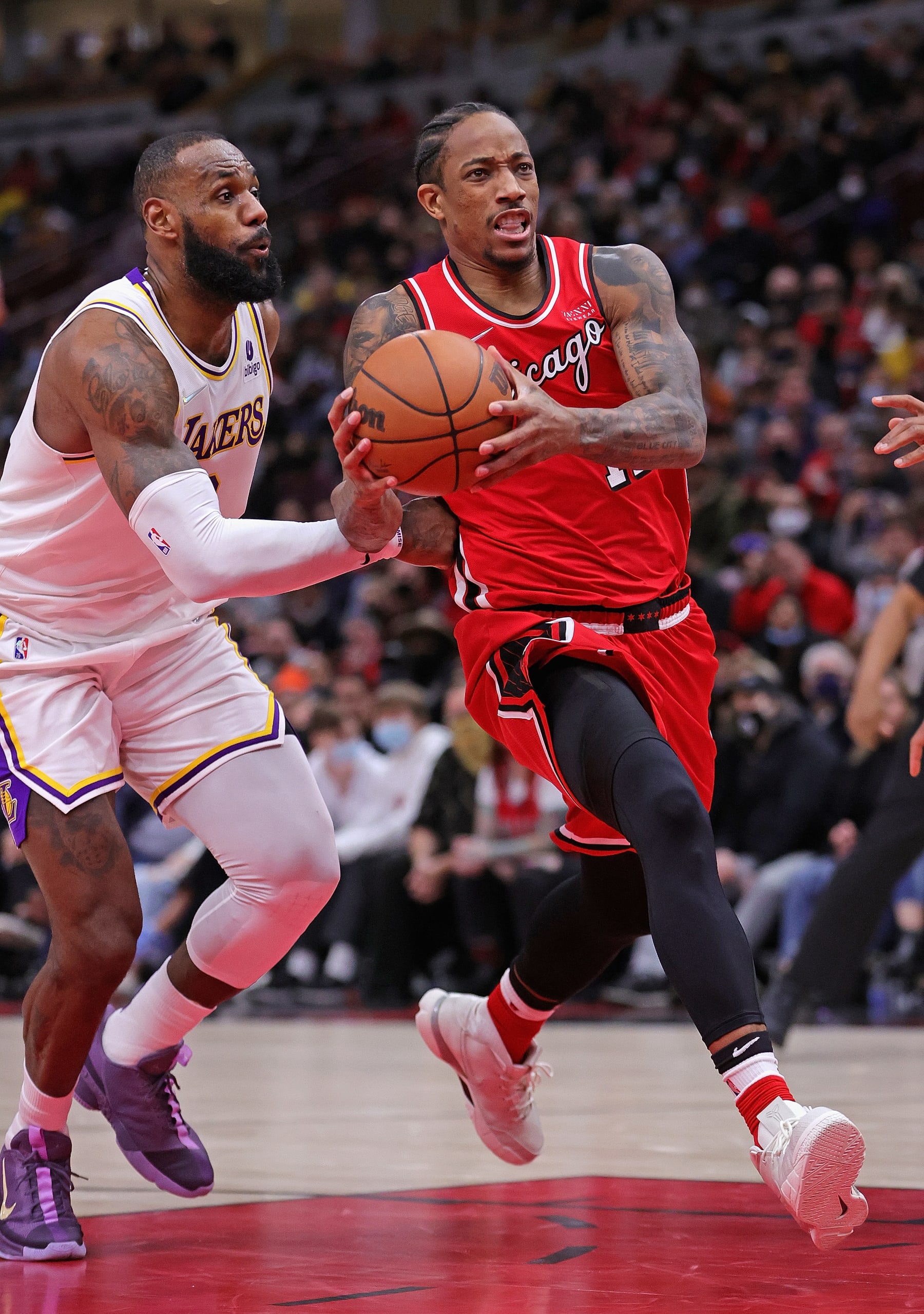 CHICAGO, ILLINOIS - DECEMBER 19: DeMar DeRozan #11 of the Chicago Bulls drives past LeBron James #6 of the Los Angeles Lakers at the United Center on December 19, 2021 in Chicago, Illinois. The Bulls defeated the Lakers 115-110. NOTE TO USER: User expressly acknowledges and agrees that, by downloading and or using this photograph, User is consenting to the terms and conditions of the Getty Images License Agreement. (Photo by Jonathan Daniel/Getty Images)