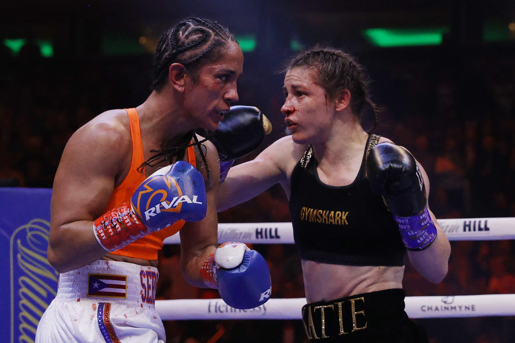 NEW YORK, NEW YORK - APRIL 30: Katie Taylor of Ireland (black trunks) trades punches with Amanda Serrano of Puerto Rico (white trunks) for the World Lightweight Title fight at Madison Square Garden on April 30, 2022 in New York, New York. This bout marks the first women’s boxing fight to headline Madison Square Garden in the venue’s history. Taylor defeated Serrano on a judges decision. (Photo by Sarah Stier/Getty Images)
