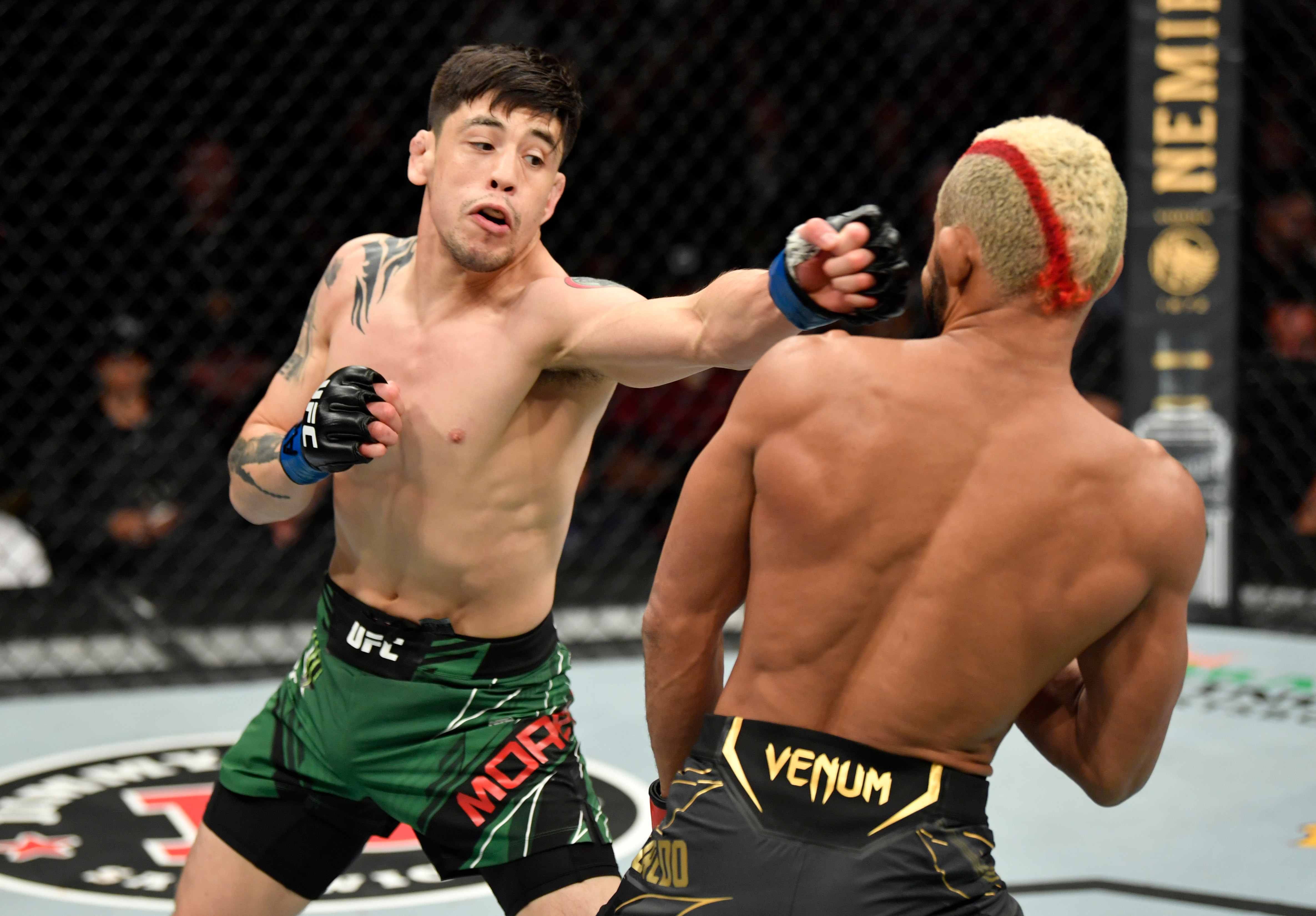 GLENDALE, ARIZONA - JUNE 12: (L-R) Brandon Moreno of Mexico punches Deiveson Figueiredo of Brazil in their UFC flyweight championship fight during the UFC 263 event at Gila River Arena on June 12, 2021 in Glendale, Arizona. (Photo by Jeff Bottari/Zuffa LLC)