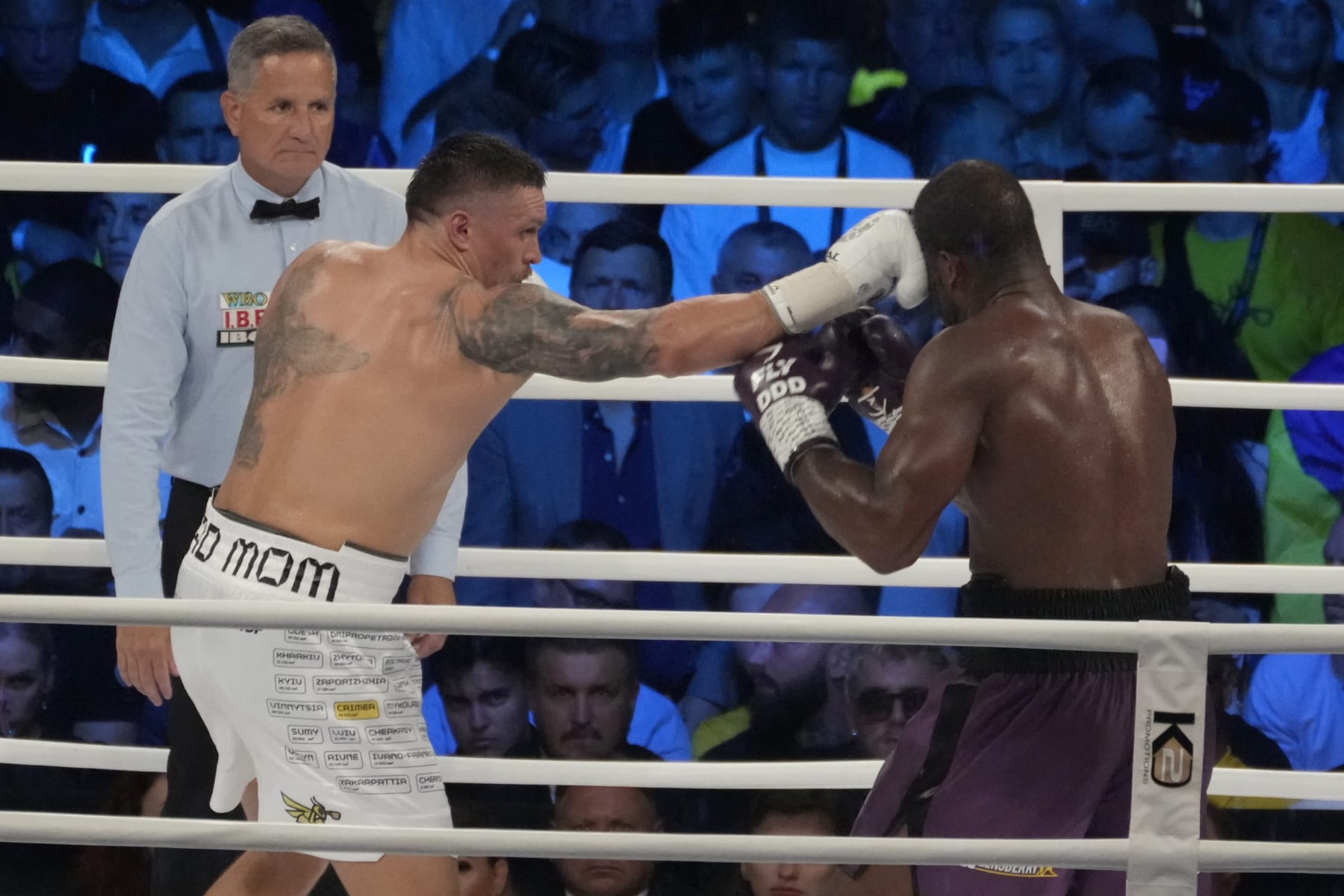 Ukraine's Oleksandr Usyk, left, lands a blow on Britain's Daniel Dubois during their world heavyweight title fight at Tarczynski Arena in Wroclaw, Poland, Sunday, Aug. 27, 2023. Oleksandr Usyk defends his WBC, IBF and WBA heavyweight titles for the first time in a year when he faces hard-hitting British challenger Daniel Dubois in a clash of styles. (AP Photo/Czarek Sokolowski)