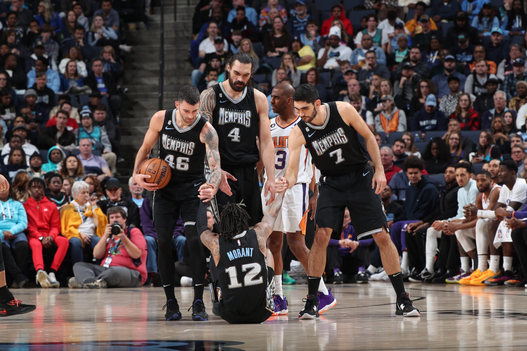 MEMPHIS, TN - DECEMBER 27: Ja Morant #12 of the Memphis Grizzlies is helped up by teammates on December 27, 2022 at FedExForum in Memphis, Tennessee. NOTE TO USER: User expressly acknowledges and agrees that, by downloading and or using this photograph, User is consenting to the terms and conditions of the Getty Images License Agreement. Mandatory Copyright Notice: Copyright 2022 NBAE (Photo by Joe Murphy/NBAE via Getty Images)