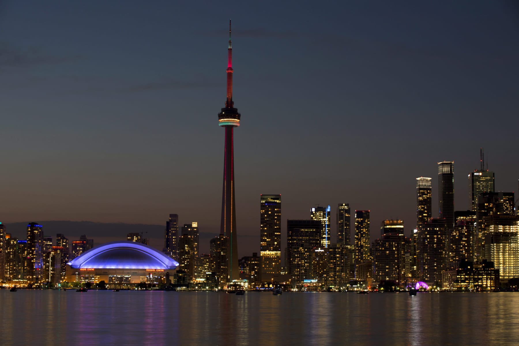 FILE - In this July 26, 2015 file photo, the sun sets over the CN Tower and Rogers Centre during the closing ceremonies of the Pan Am Games in Toronto. Toronto’s attractions are getting an extra dose of attention because the city is hosting the 2016 NBA All-Star game. (AP Photo/Rebecca Blackwell, File)