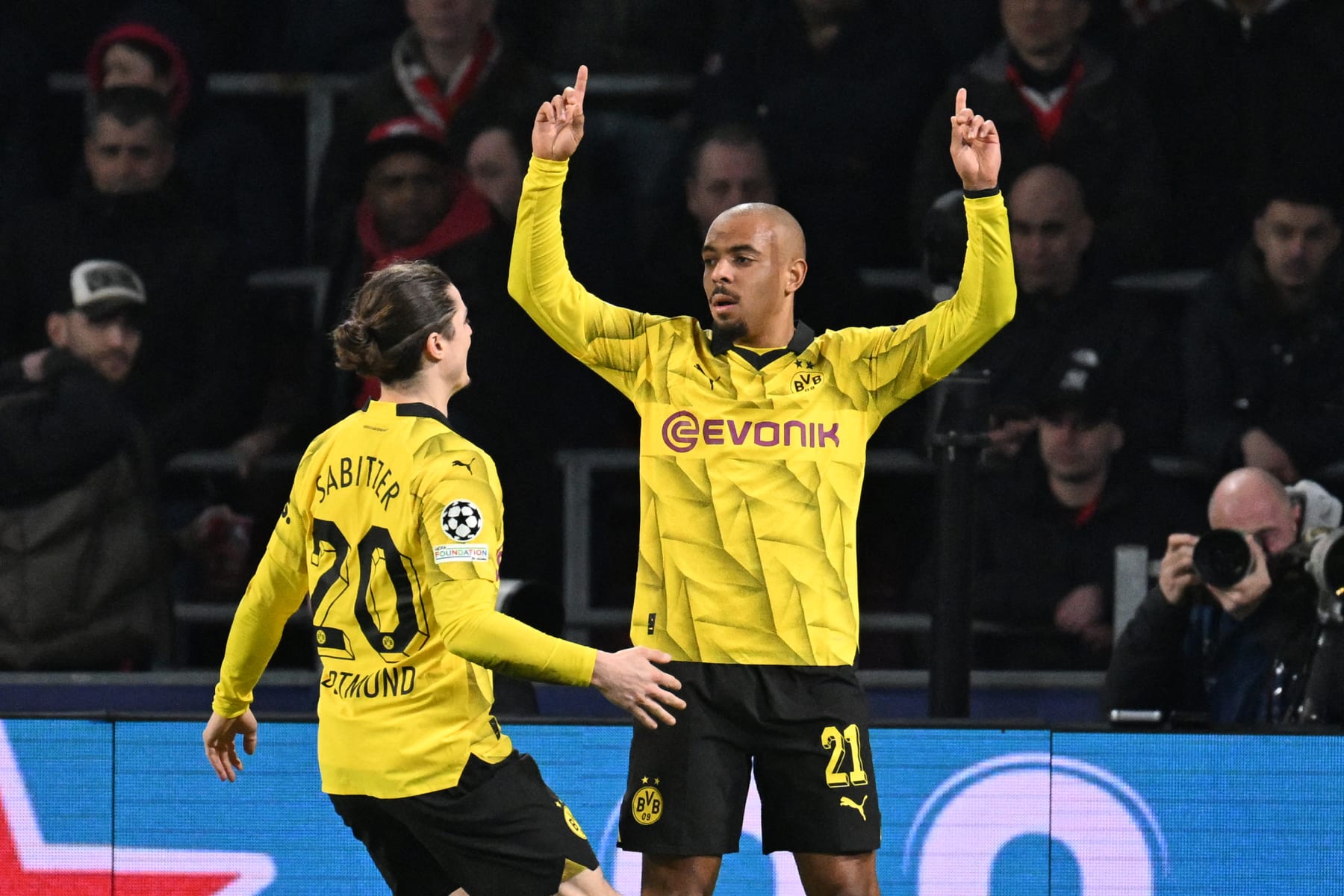 Dortmund's Dutch forward #21 Donyell Malen (R) celebrates scoring the first goal of the match during the UEFA Champions League round of 16, first leg football match between against PSV Eindhoven and Borussia Dortmund at the The Philips Stadium, in Eindhoven on February 20, 2024. (Photo by JOHN THYS / AFP) (Photo by JOHN THYS/AFP via Getty Images)