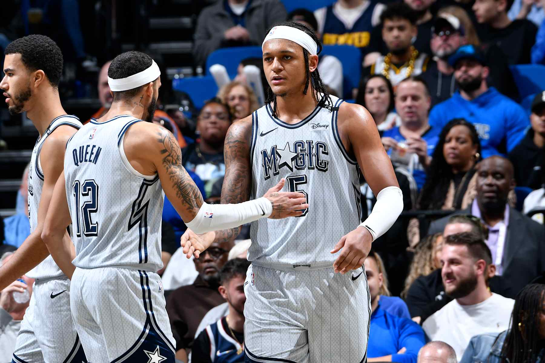 ORLANDO, FL - JANUARY 19:  Trevelin Queen #12 and Paolo Banchero #5 of the Orlando Magic high five during the game against the Denver Nuggets  on January 19, 2025 at Kia Center in Orlando, Florida. NOTE TO USER: User expressly acknowledges and agrees that, by downloading and or using this photograph, User is consenting to the terms and conditions of the Getty Images License Agreement. Mandatory Copyright Notice: Copyright 2024 NBAE (Photo by Fernando Medina/NBAE via Getty Images)