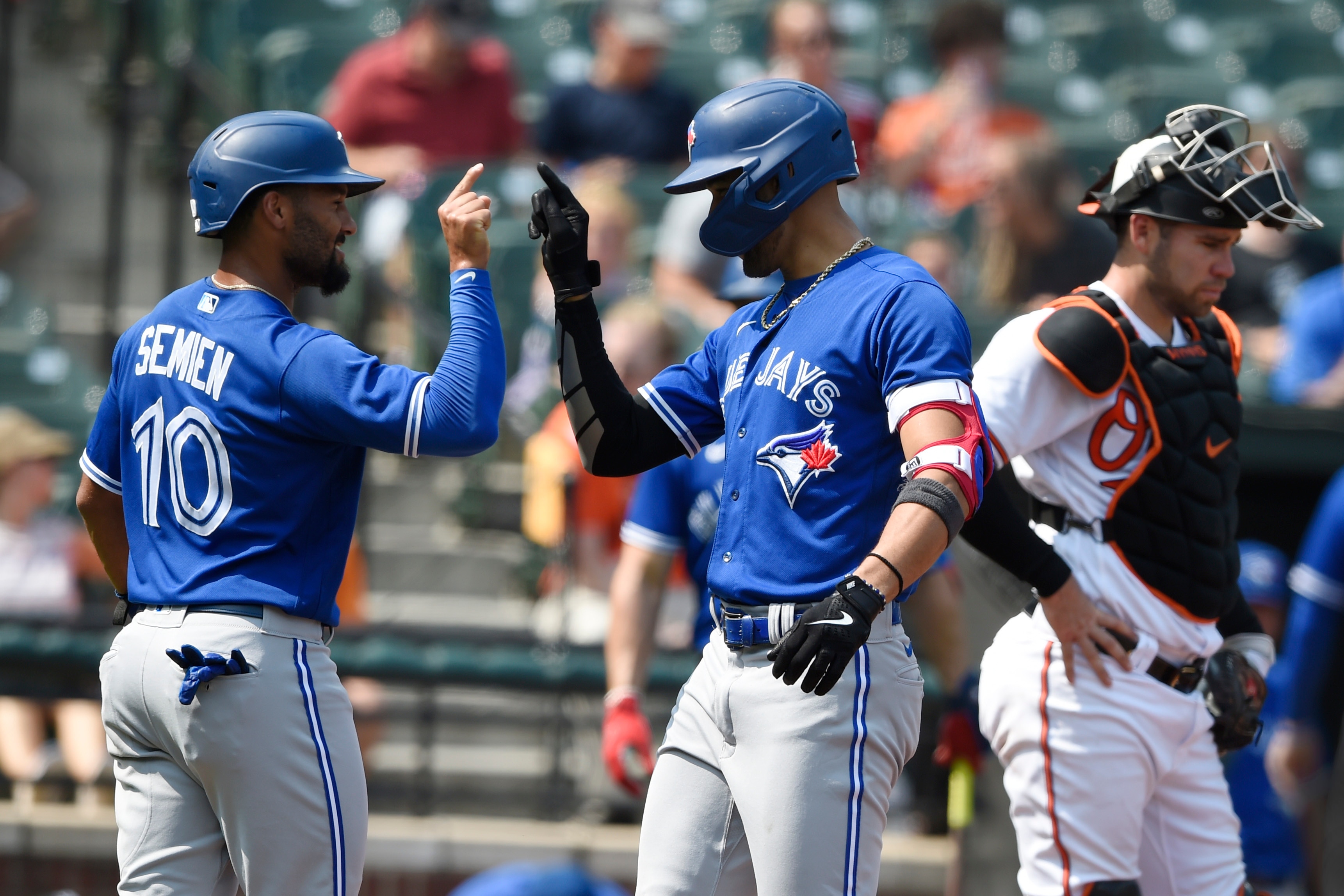 Toronto Blue Jays' Lourdes Gurriel Jr. right, is congratulated by Marcus Semien after hitting a grand slam against the Baltimore Orioles in the first inning of a baseball game Sunday, Sept. 12, 2021, in Baltimore. (AP Photo/Gail Burton)