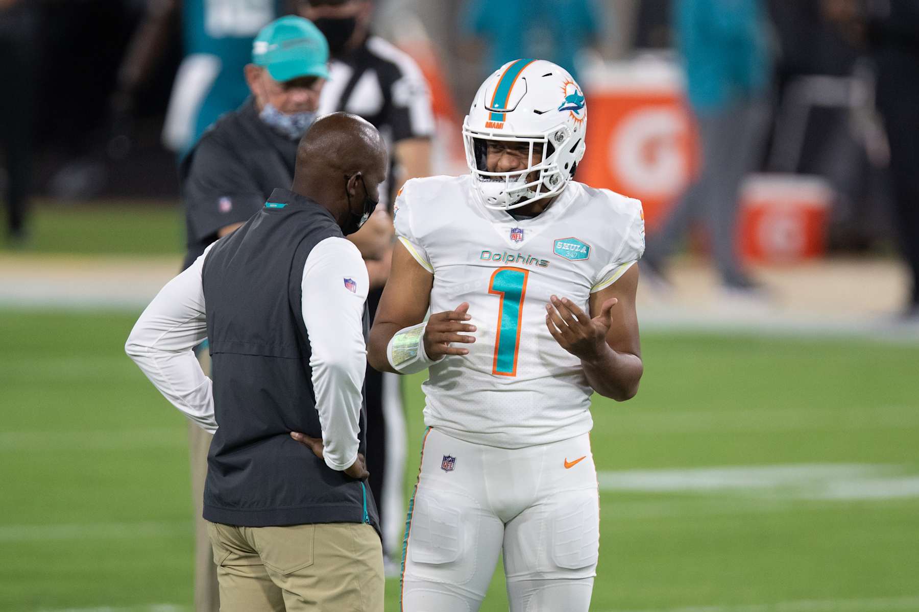 JACKSONVILLE, FL - SEPTEMBER 24: Tua Tagovailoa #1 of the Miami Dolphins talks with head coach Brian Flores during warm ups prior to an NFL football game against the Jacksonville Jaguars at TIAA Bank Field on September 24, 2020 in Jacksonville, Florida. (Photo by Perry Knotts/Getty Images)