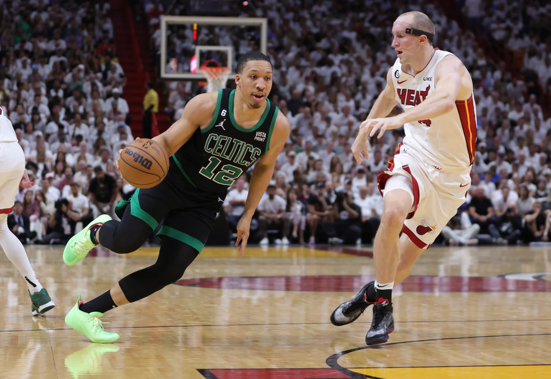 MIAMI, FLORIDA - MAY 21: Grant Williams #12 of the Boston Celtics drives against Cody Zeller #44 of the Miami Heat during the second quarter in game three of the Eastern Conference Finals at Kaseya Center on May 21, 2023 in Miami, Florida. NOTE TO USER: User expressly acknowledges and agrees that, by downloading and or using this photograph, User is consenting to the terms and conditions of the Getty Images License Agreement. (Photo by Megan Briggs/Getty Images)