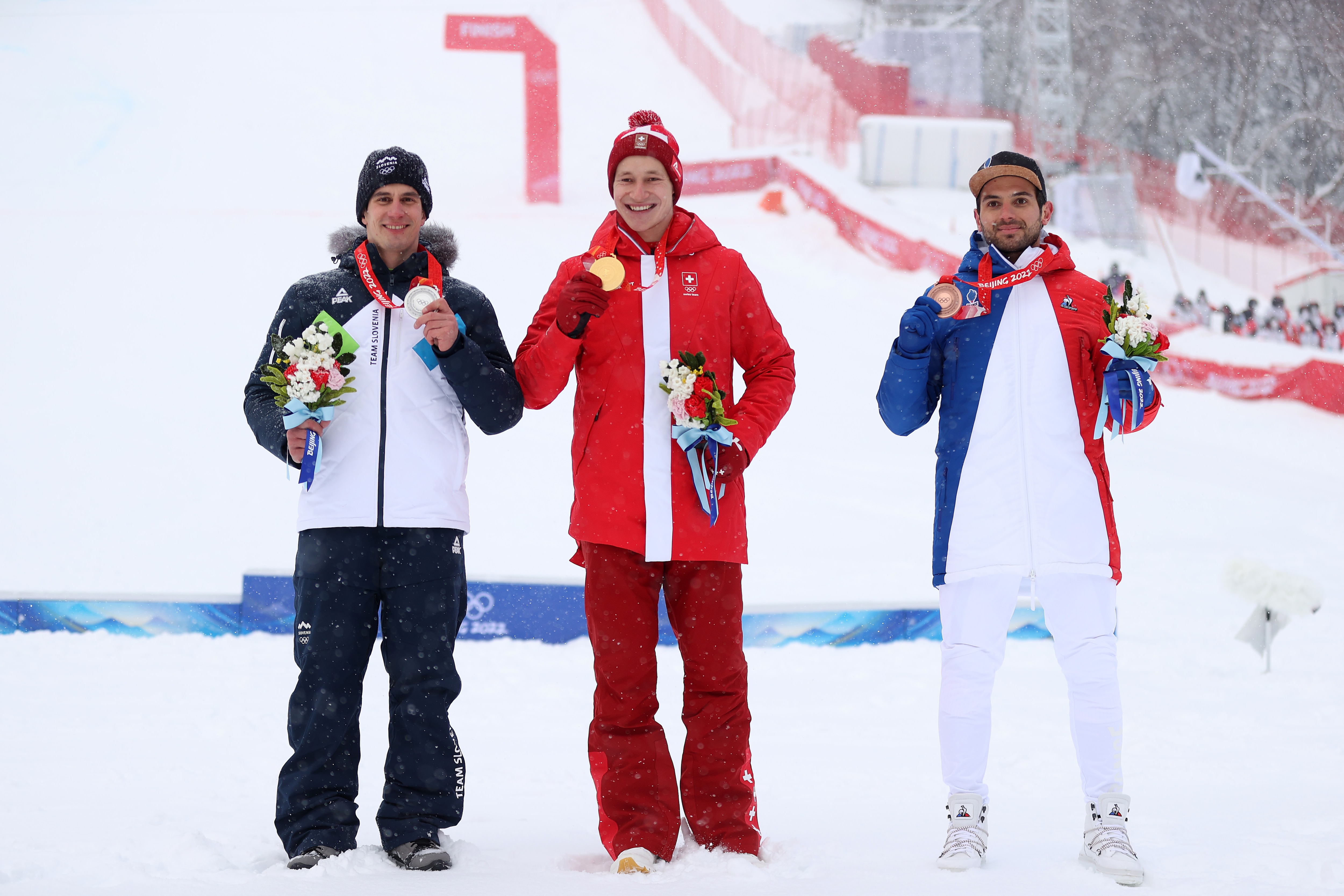 YANQING, CHINA - FEBRUARY 13: Gold medalist Marco Odermatt of Team Switzerland (C), Silver medalist Zan Kranjec of Team Slovenia (L) and Bronze medalist Mathieu Faivre of Team France (R) pose during the Men's Giant Slalom medal ceremony on day nine of the Beijing 2022 Winter Olympic Games at National Alpine Ski Centre on February 13, 2022 in Yanqing, China. (Photo by Alex Pantling/Getty Images)