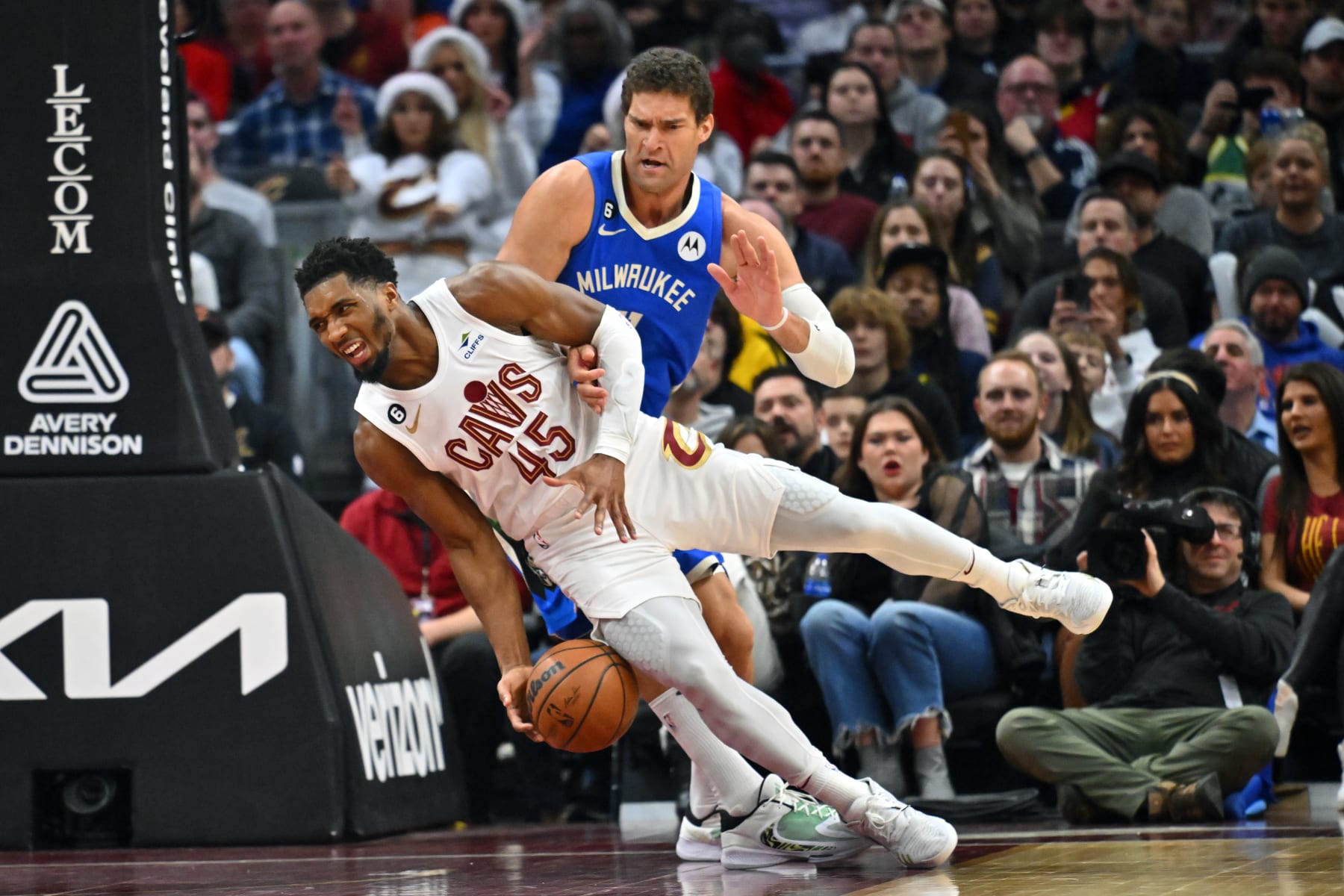 CLEVELAND, OHIO - DECEMBER 21: Donovan Mitchell #45 of the Cleveland Cavaliers trips over Brook Lopez #11 of the Milwaukee Bucks during the fourth quarter at Rocket Mortgage Fieldhouse on December 21, 2022 in Cleveland, Ohio. The Cavaliers defeated the Bucks 114-106. NOTE TO USER: User expressly acknowledges and agrees that, by downloading and or using this photograph, User is consenting to the terms and conditions of the Getty Images License Agreement. (Photo by Jason Miller/Getty Images)
