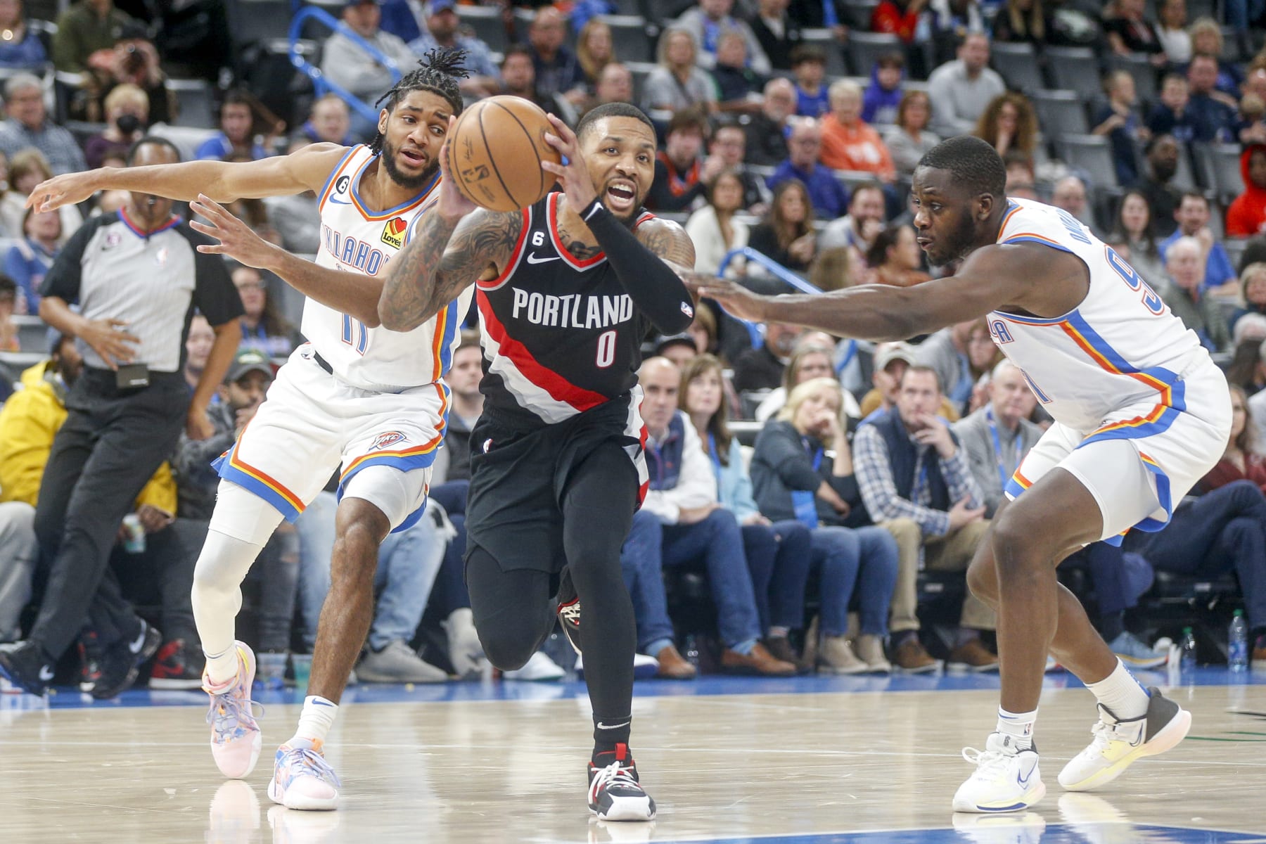 OKLAHOMA CITY, OKLAHOMA - DECEMBER 19: Damian Lillard #0 of the Portland Trail Blazers drives past Isaiah Joe #11 of the Oklahoma City Thunder and Eugene Omoruyi #97 of the Oklahoma City Thunder during the fourth quarter at Paycom Center on December 19, 2022 in Oklahoma City, Oklahoma. NOTE TO USER: User expressly acknowledges and agrees that, by downloading and or using this photograph, User is consenting to the terms and conditions of the Getty Images License Agreement.  (Photo by Ian Maule/Getty Images)