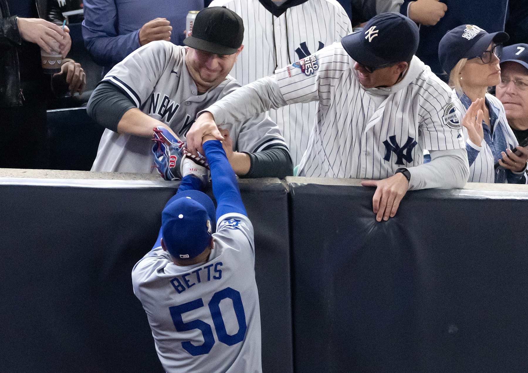 NEW YORK, NEW YORK - OCTOBER 29: Fans interfere with Mookie Betts #50 of the Los Angeles Dodgers as he attempts to catch a fly ball in foul territory during the first inning of Game Four of the 2024 World Series against the New York Yankees at Yankee Stadium on October 29, 2024 in the Bronx borough of New York City. The play resulted in an out.  (Photo by Al Bello/Getty Images)