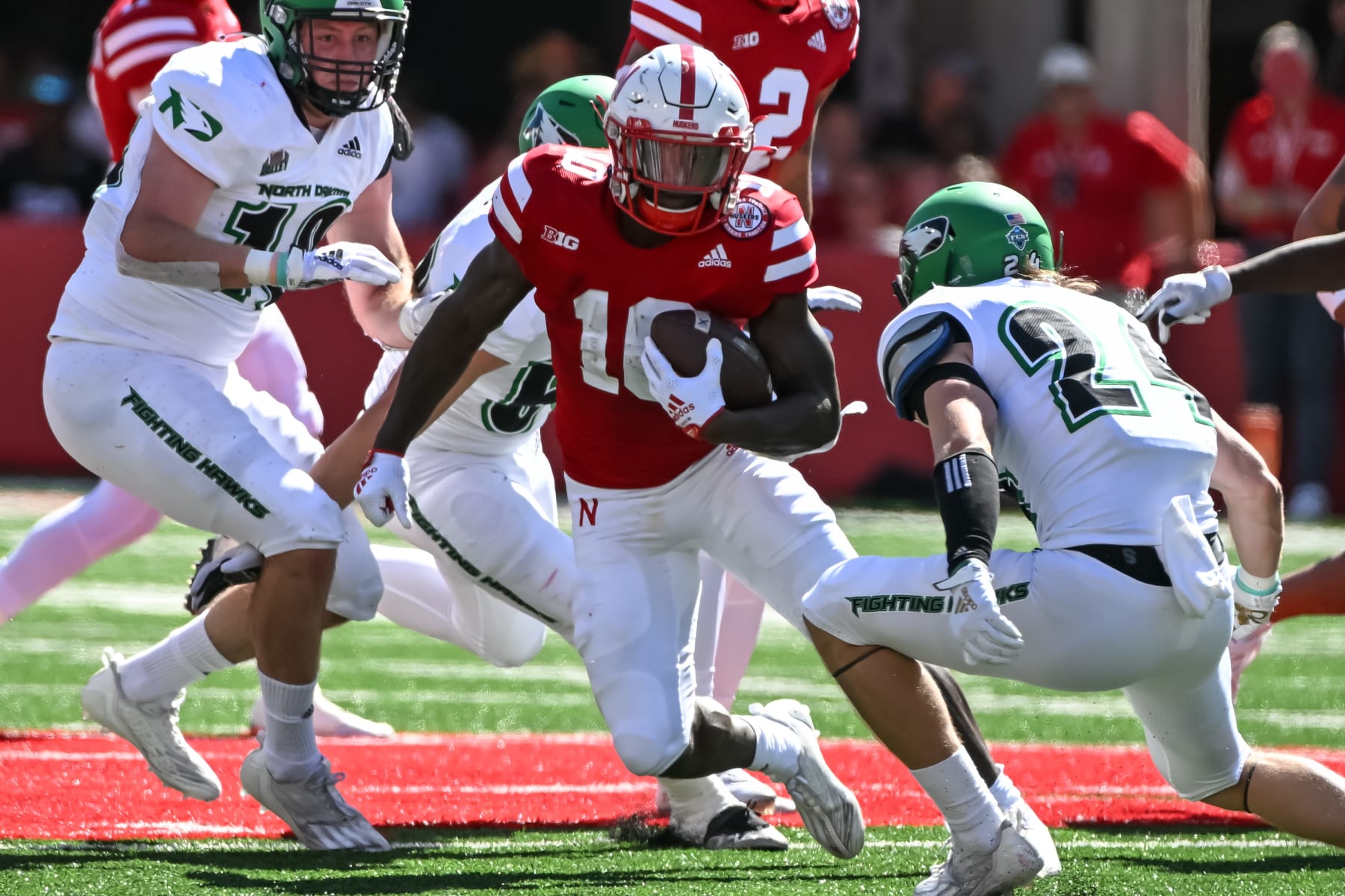LINCOLN, NE - SEPTEMBER 3: Running back Anthony Grant #10 of the Nebraska Cornhuskers runs from defensive back Kadon Kauppinen #24 of the North Dakota Fighting Hawks in the first quarter at Memorial Stadium on September 3, 2022 in Lincoln, Nebraska. (Photo by Steven Branscombe/Getty Images)