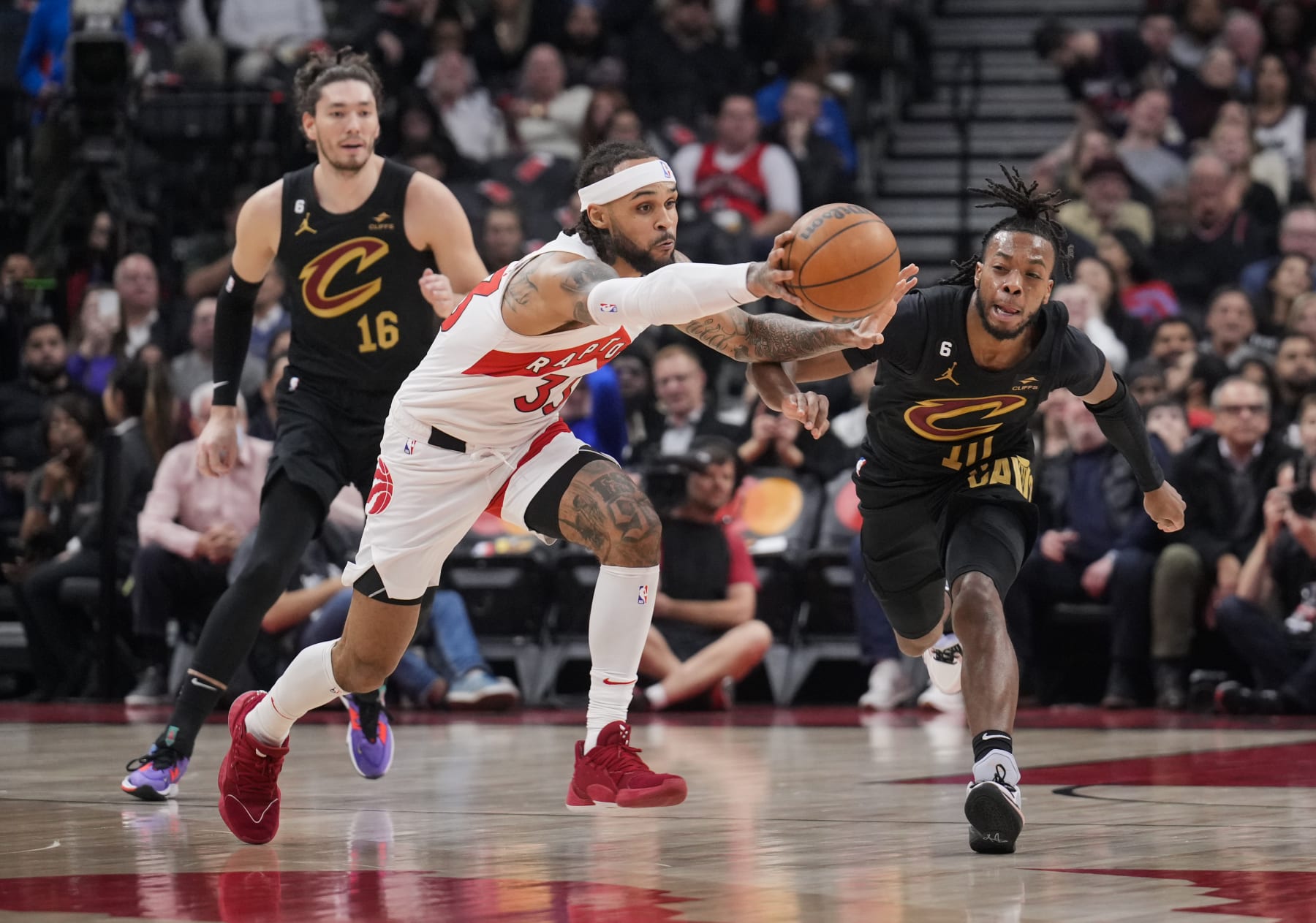 TORONTO, ON - NOVEMBER 28: Gary Trent Jr. #33 of the Toronto Raptors battles for the ball with Darius Garland #10 of the Cleveland Cavaliers during the first half of their basketball game at the Scotiabank Arena on November 28, 2022 in Toronto, Ontario, Canada. NOTE TO USER: User expressly acknowledges and agrees that, by downloading and/or using this Photograph, user is consenting to the terms and conditions of the Getty Images License Agreement. (Photo by Mark Blinch/Getty Images)
