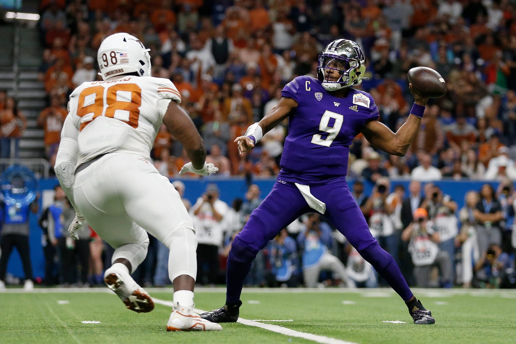 SAN ANTONIO, TEXAS - DECEMBER 29: Michael Penix Jr. #9 of the Washington Huskies throws a pass under pressure by Moro Ojomo #98 of the Texas Longhorns in the first quarter during the Valero Alamo Bowl at Alamodome on December 29, 2022 in San Antonio, Texas. (Photo by Tim Warner/Getty Images)