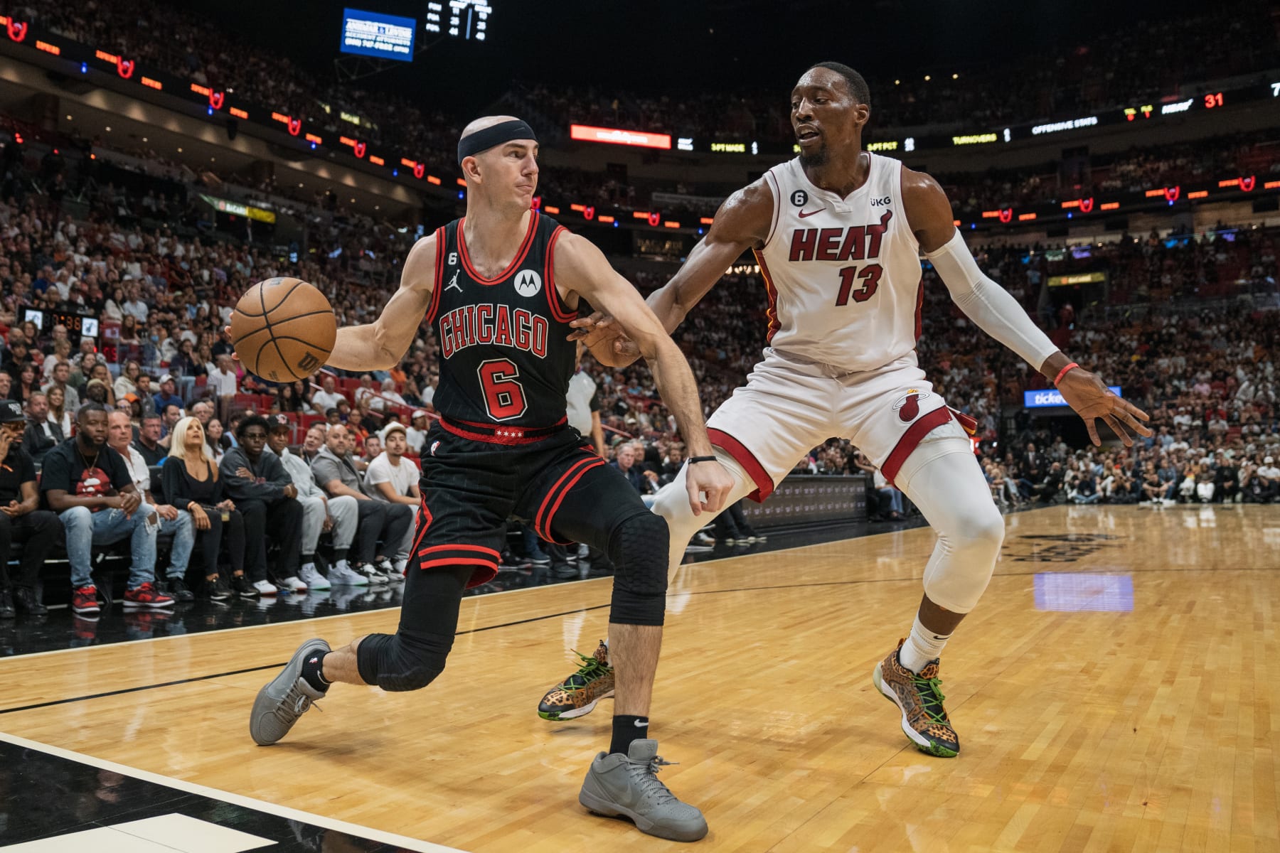 MIAMI, FL - APRIL 14: Alex Caruso #6 of the Chicago Bulls passes the ball while being defended by Bam Adebayo #13 of the Miami Heat during the second quarter at Kaseya Center on April 14, 2023 in Miami, Florida. NOTE TO USER: User expressly acknowledges and agrees that, by downloading and or using this Photograph, user is consenting to the terms and conditions of the Getty Images License Agreement. (Photo by Bryan Cereijo/Getty Images)