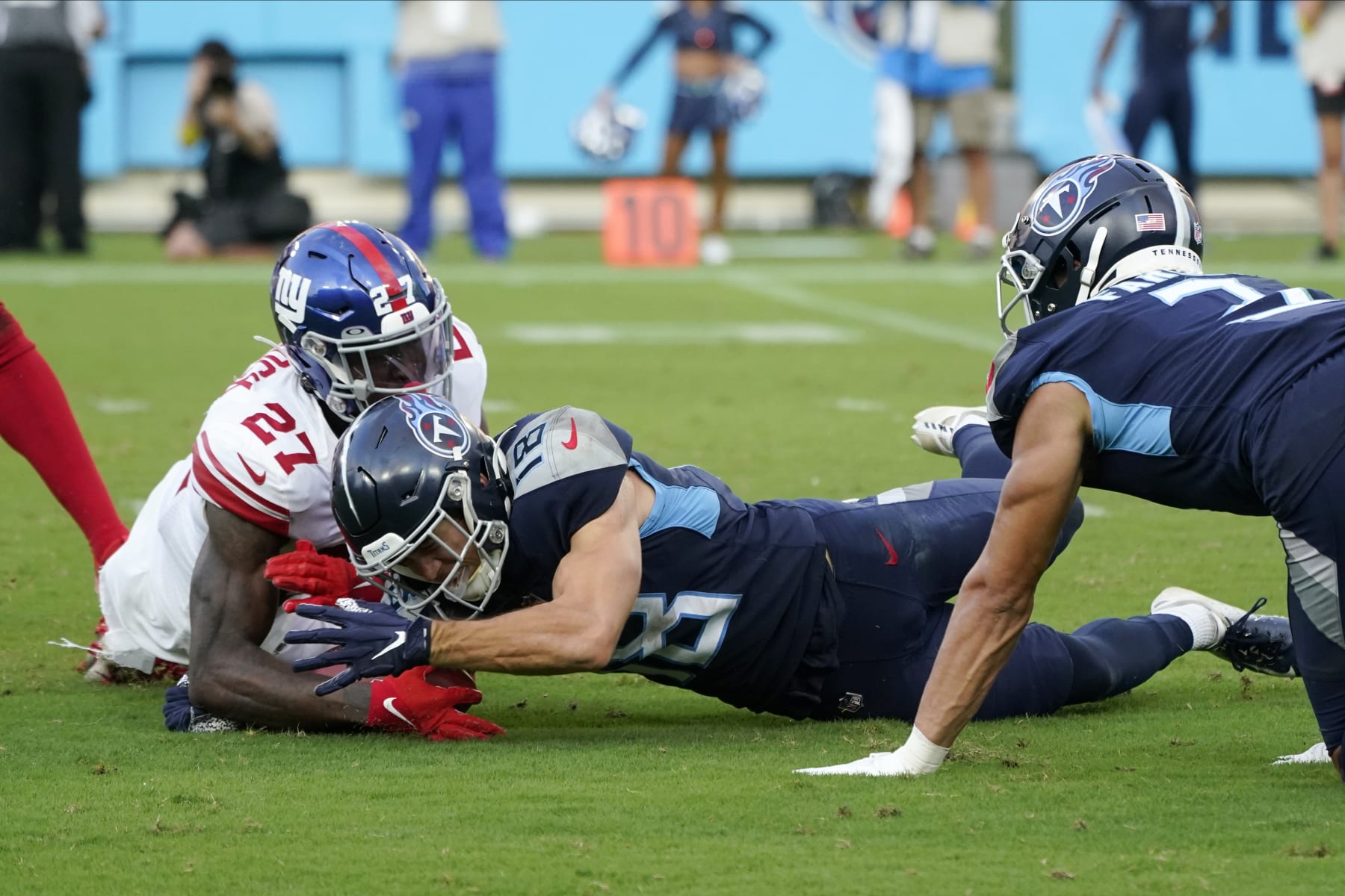 Tennessee Titans' Kyle Philips (18) fumbles a punt as the New York Giants' Jason Pinnock (27) recovers the ball during the second half of an NFL football game Sunday, Sept. 11, 2022, in Nashville. (AP Photo/Mark Humphrey)