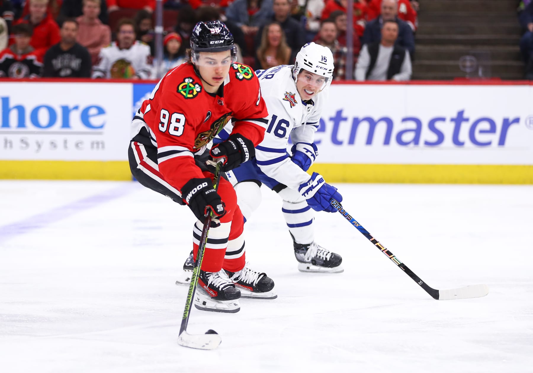 CHICAGO, IL - NOVEMBER 24: Connor Bedard #98 of the Chicago Blackhawks controls the puck against  Mitchell Marner #16 of the Toronto Maple Leafs during the third period at the United Center on November 24, 2023 in Chicago, Illinois. (Photo by Melissa Tamez/Icon Sportswire via Getty Images)