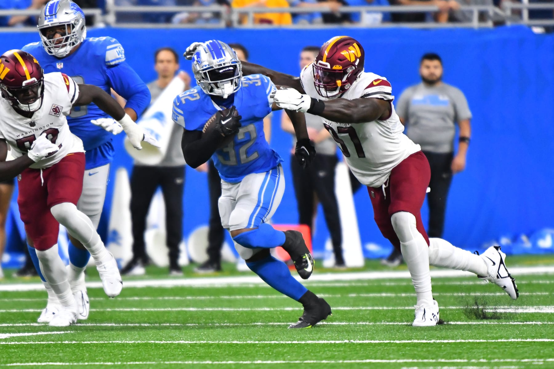 DETROIT, MI - SEPTEMBER 18: Detroit Lions running back D'Andre Swift (32) runs for a first down while pursued by Washington Commanders cornerback Rachad Wildgoose (37) during the Detroit Lions versus the Washington Commanders game on Sunday September 18, 2022 at Ford Field in Detroit, MI. (Photo by Steven King/Icon Sportswire via Getty Images)