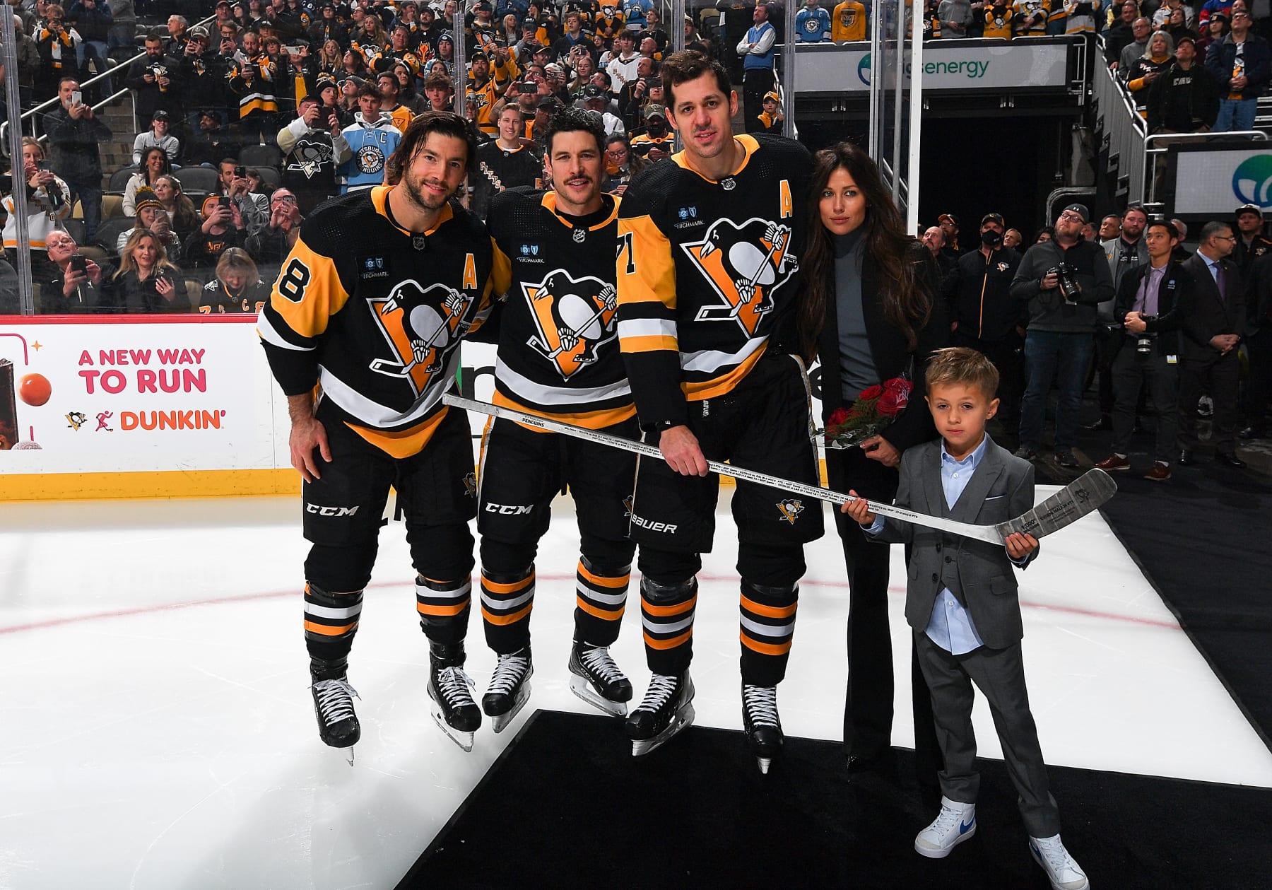 PITTSBURGH, PA - NOVEMBER 23:  Evgeni Malkin #71and family pose with a stick honoring his 1000th NHL game Kris Letang #58 and Sidney Crosby #87 of the Pittsburgh Penguins prior to the game against the Calgary Flames at PPG PAINTS Arena on November 23, 2022 in Pittsburgh, Pennsylvania. (Photo by Joe Sargent/NHLI via Getty Images)