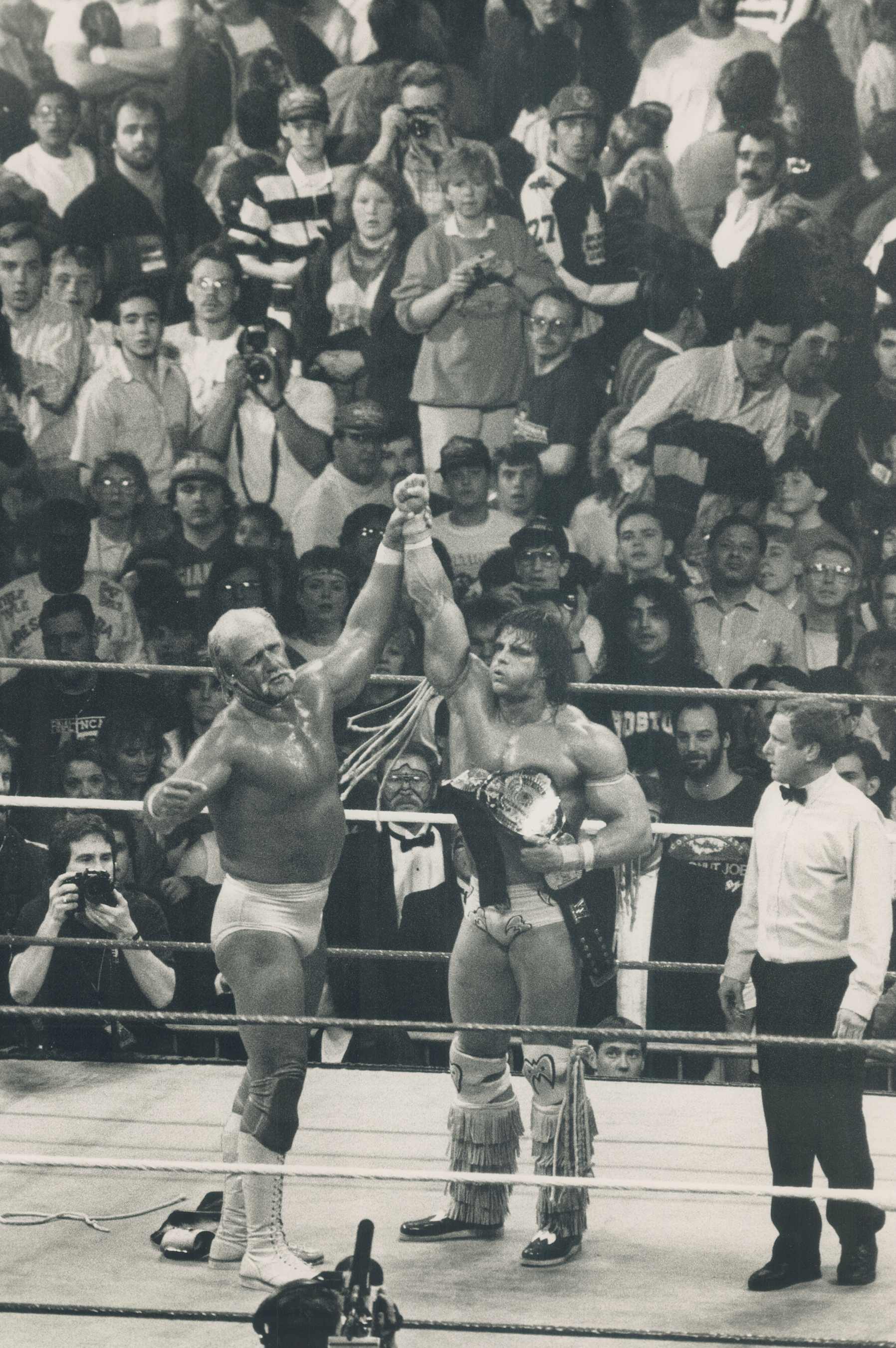 CANADA - APRIL 01:  Hald to the champ: A sportsman to the end; Hulk Hogan hoists the hand of the new champ; who clutches the belt attesting he is wrestling's Ultimate Warrior.   (Photo by Patti Gower/Toronto Star via Getty Images)